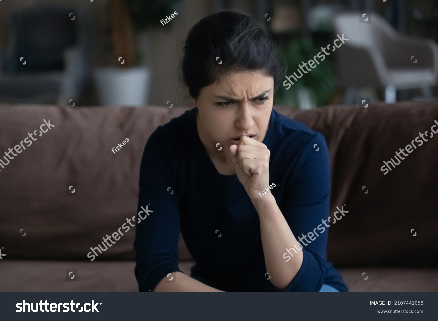 Unhealthy young Indian woman coughing, suffering from bronchitis disease or painful uncomfortable feelings in throat, caught cold, first flu grippe covid19 symptoms, immunity concept. #2107441058