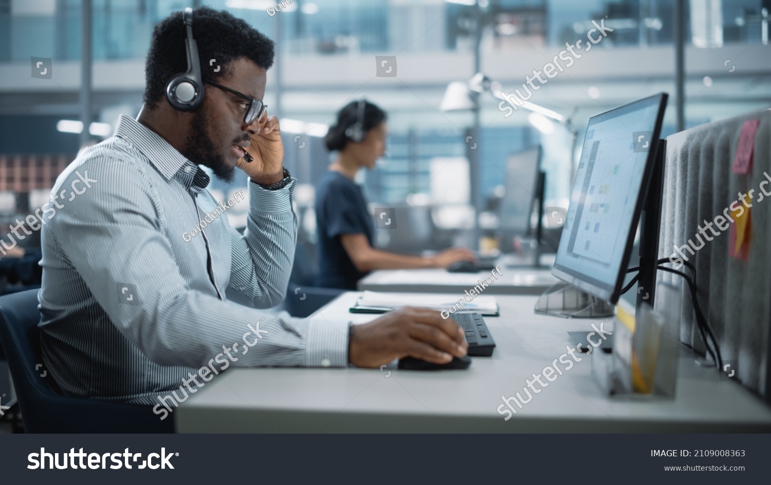 Professional Investment Traders Talking into Headset, Working on Computer with Screen Showing Finance Statistics, Charts Strategy, Stock Market, Telemarketing. Big Office Call Center. #2109008363