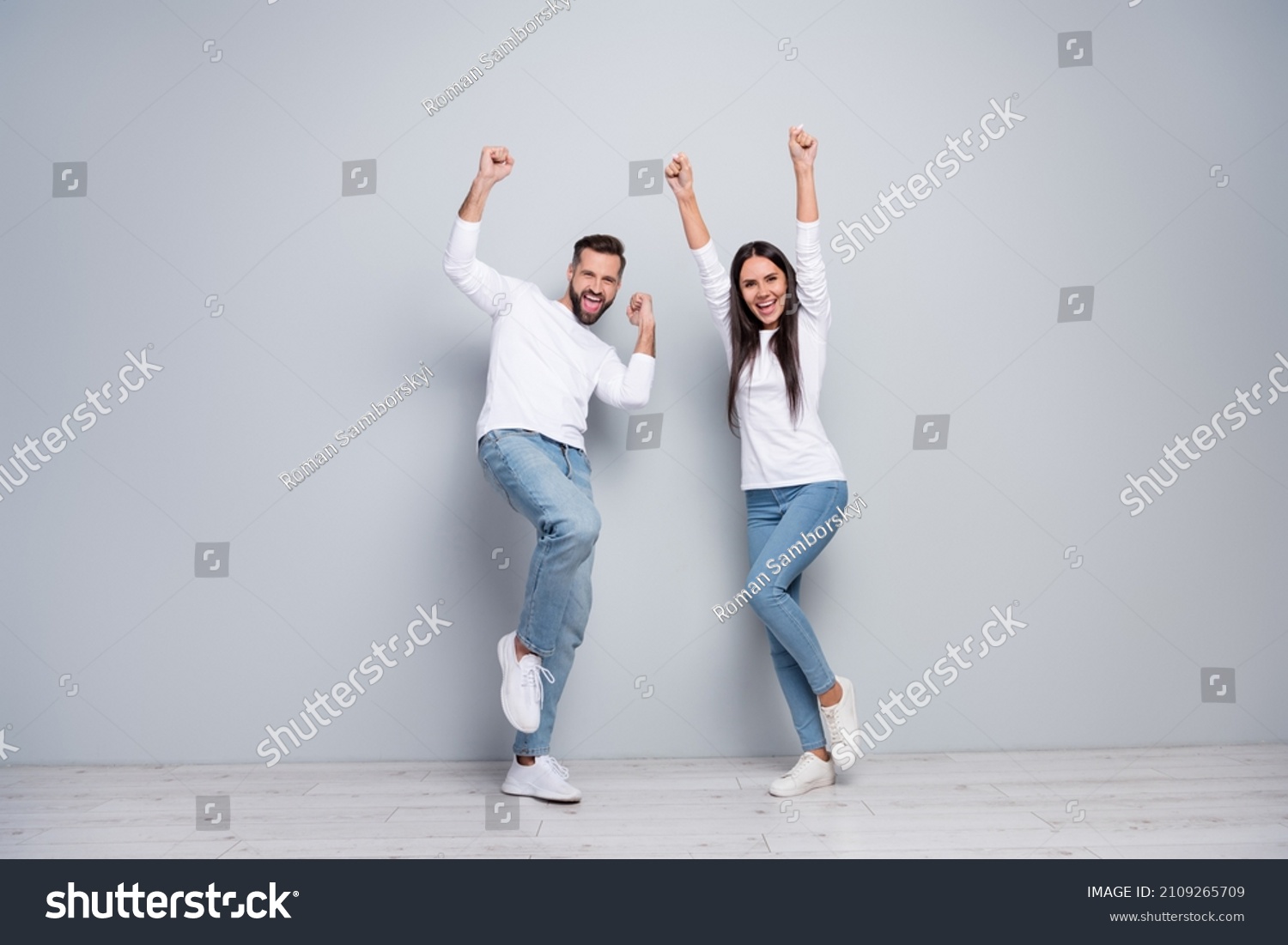 Full length photo of hooray young couple yell wear shirt jeans sneakers isolated concrete grey color wall background #2109265709