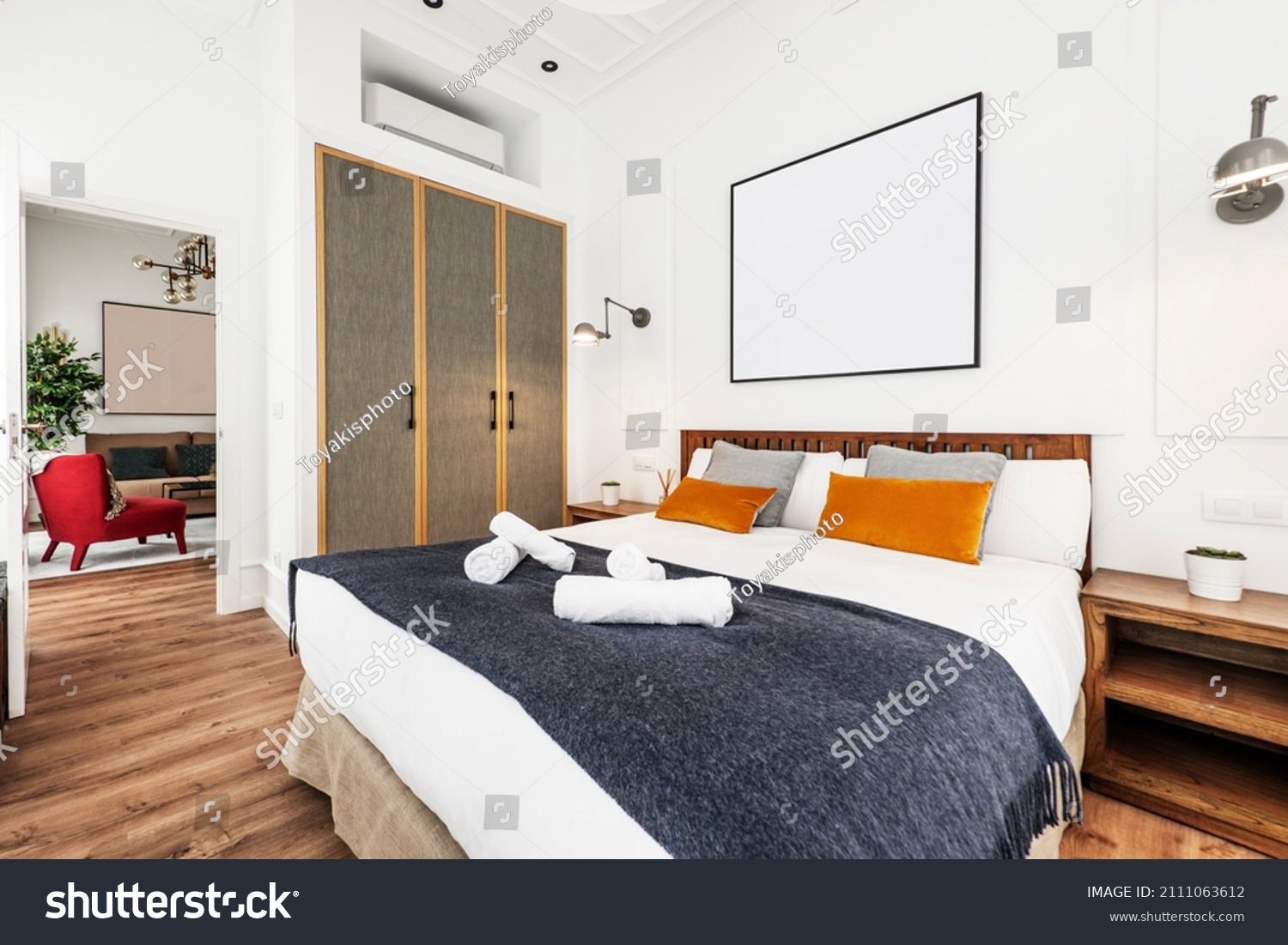 King-size bed in furnished short-term rental apartment with upholstered cupboard doors and decorative cushions #2111063612