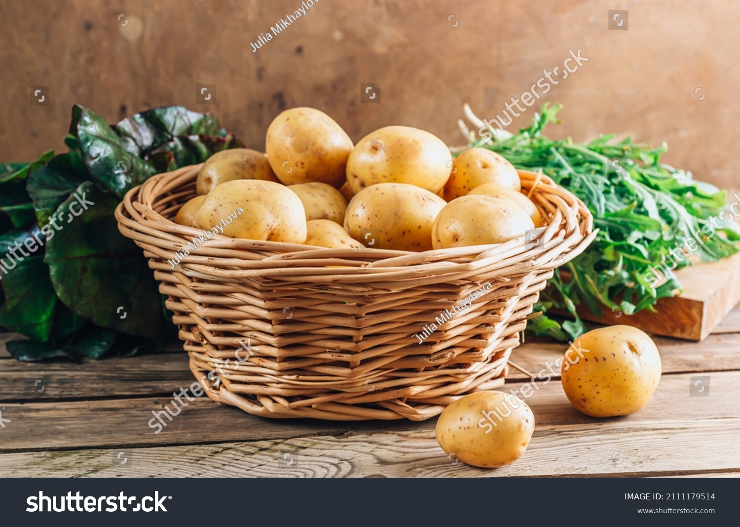 Fresh raw baby potato in a basket over wooden background. #2111179514