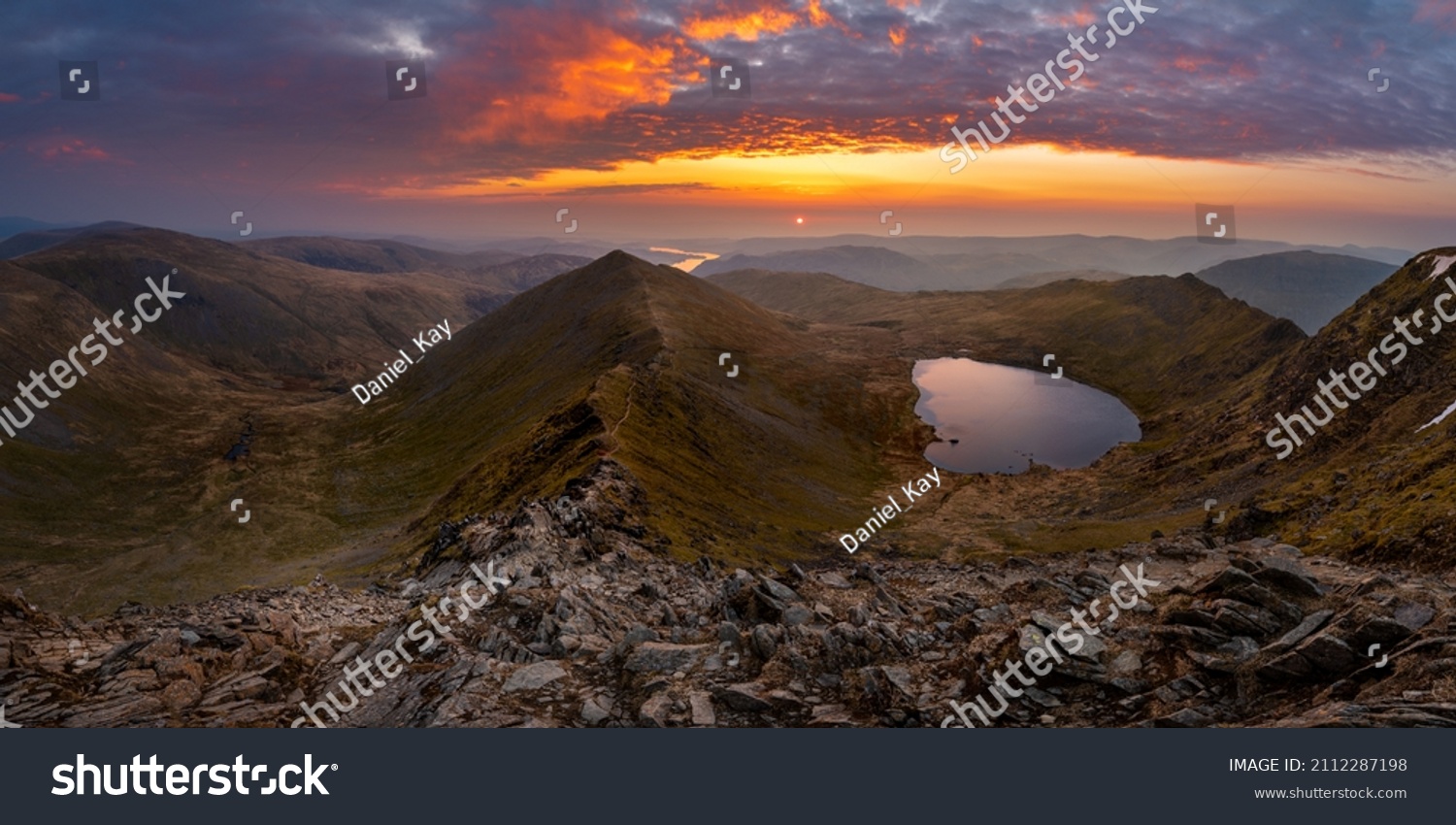 Beautiful vibrant sunrise overlooking Red Tarn and Ullswater from the summit of Helvellyn mountain range. Wide panoramic Lake District views. #2112287198