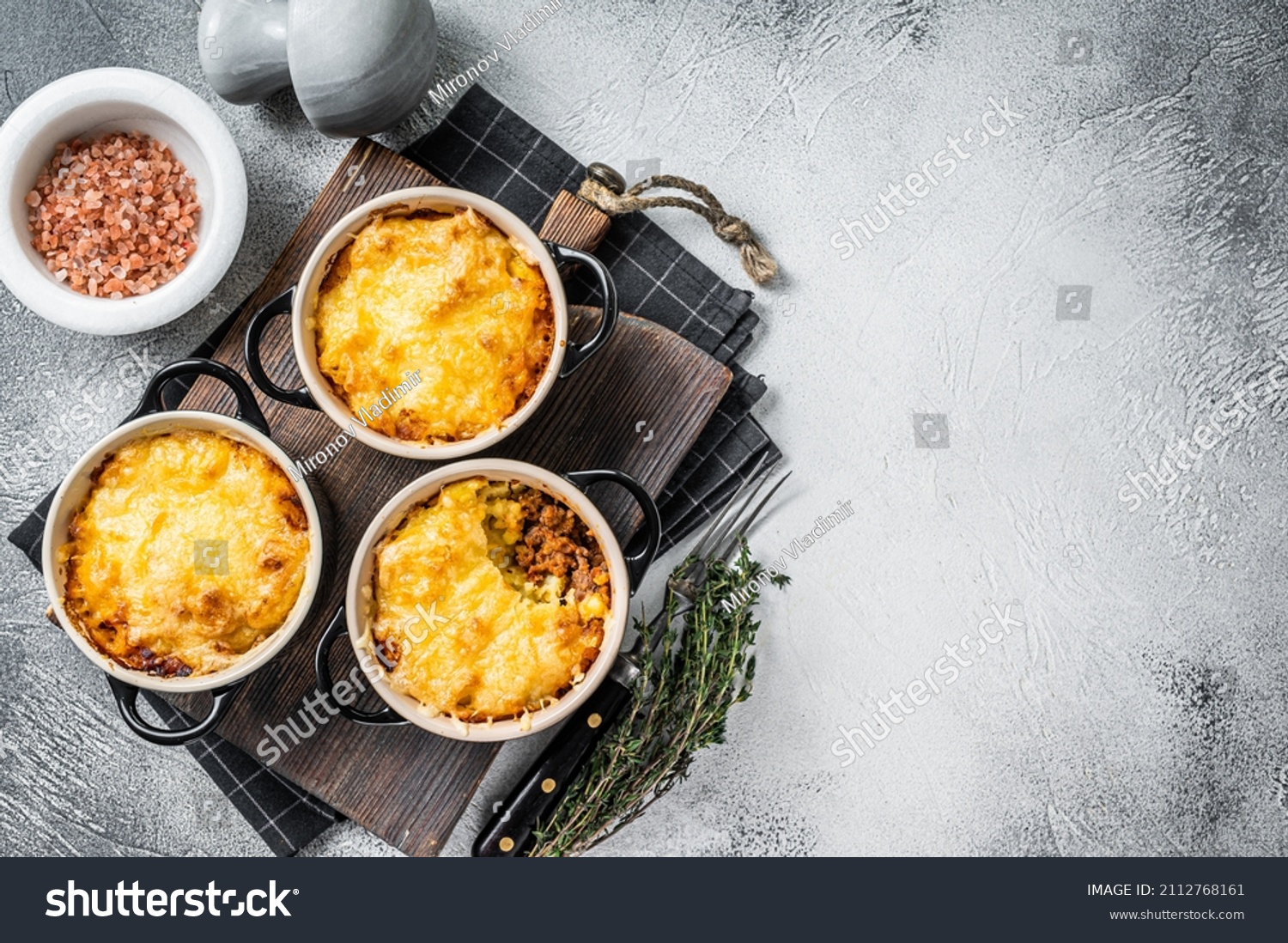 British dish Shepherd's pie with ground meat, mashed potato and cheddar cheese crust. White background. Top view. Copy space #2112768161