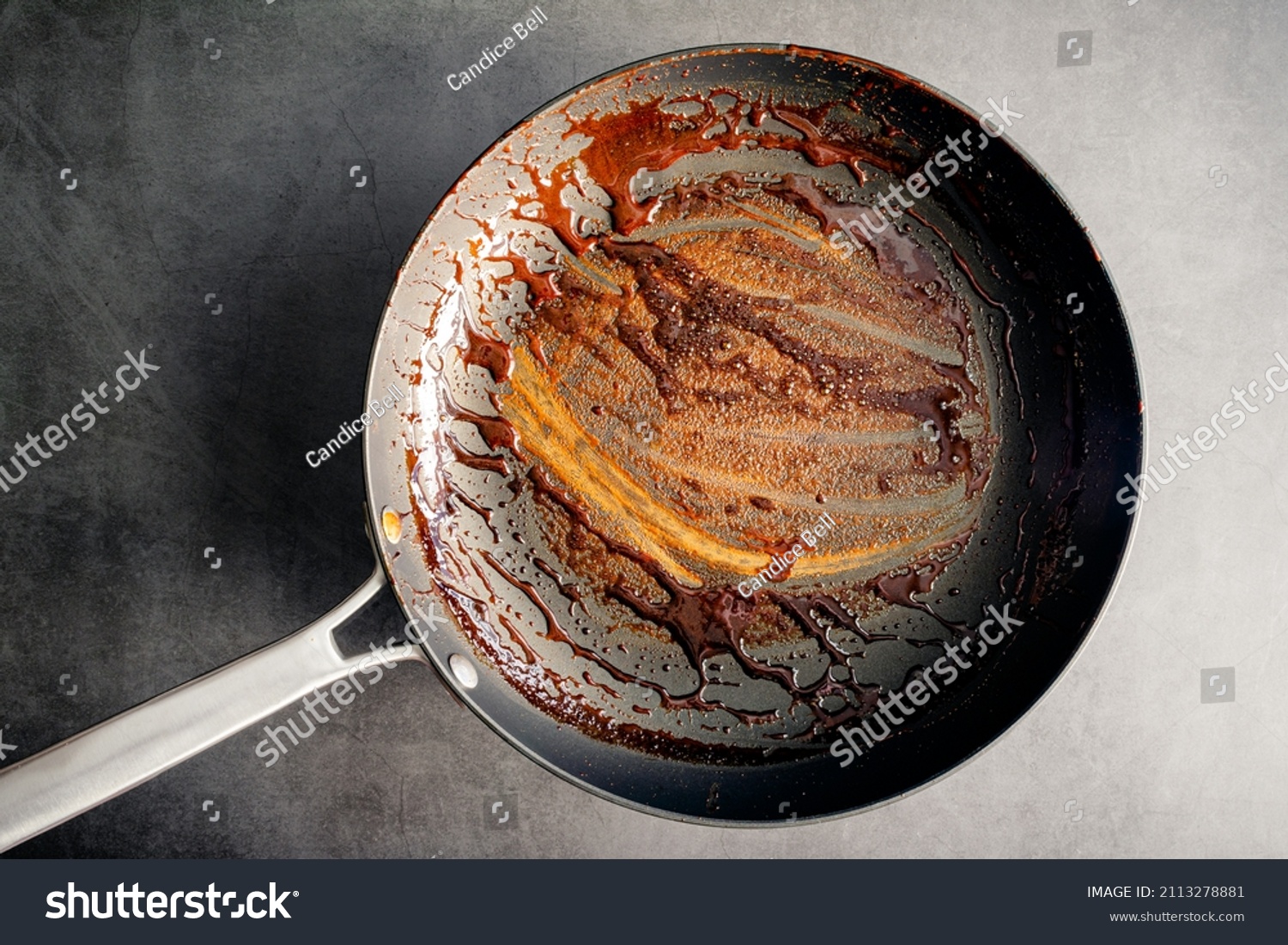 Dirty Nonstick Skillet Used to Make a Balsamic Reduction: An unwashed frying pan covered in a sticky glaze #2113278881