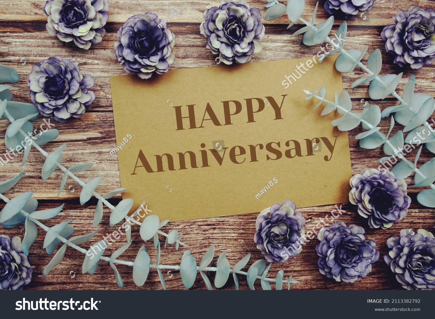 Happy Anniversary typography text on paper card decorate with flower on wooden background #2113382792