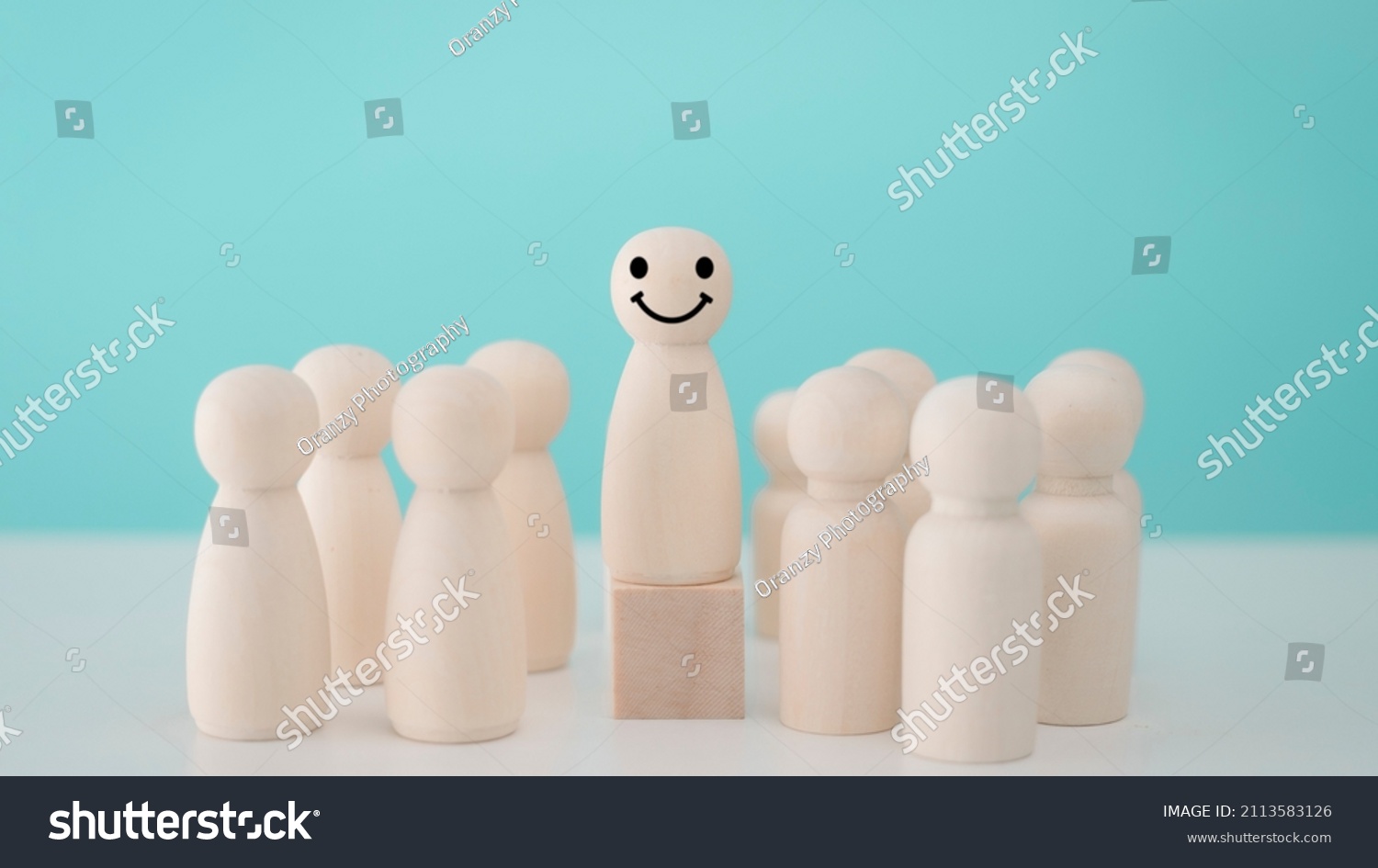 Wood person model among people Smiling .Successful team leader concept. #2113583126