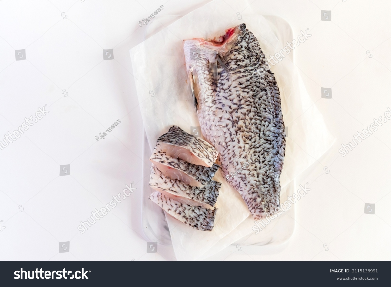 Fresh sea bass fish fillets on marble cutting board; selective focus and copy space. #2115136991