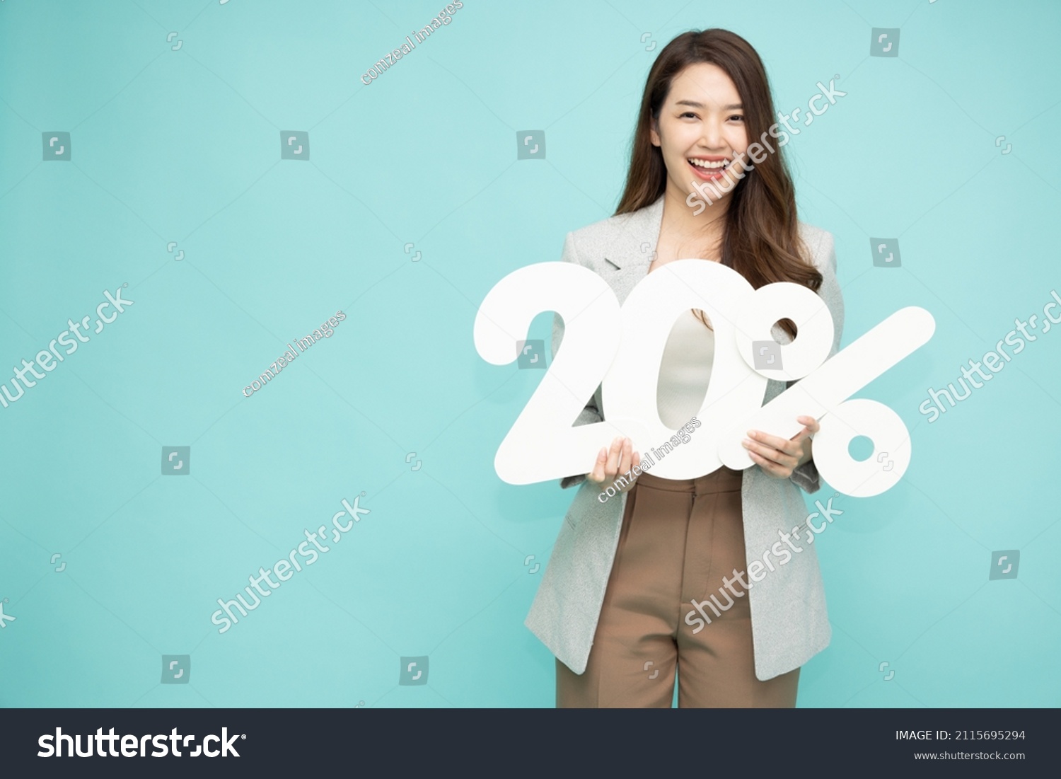 Portrait of Asian business woman holding 20% number or twenty percent isolated over green background #2115695294