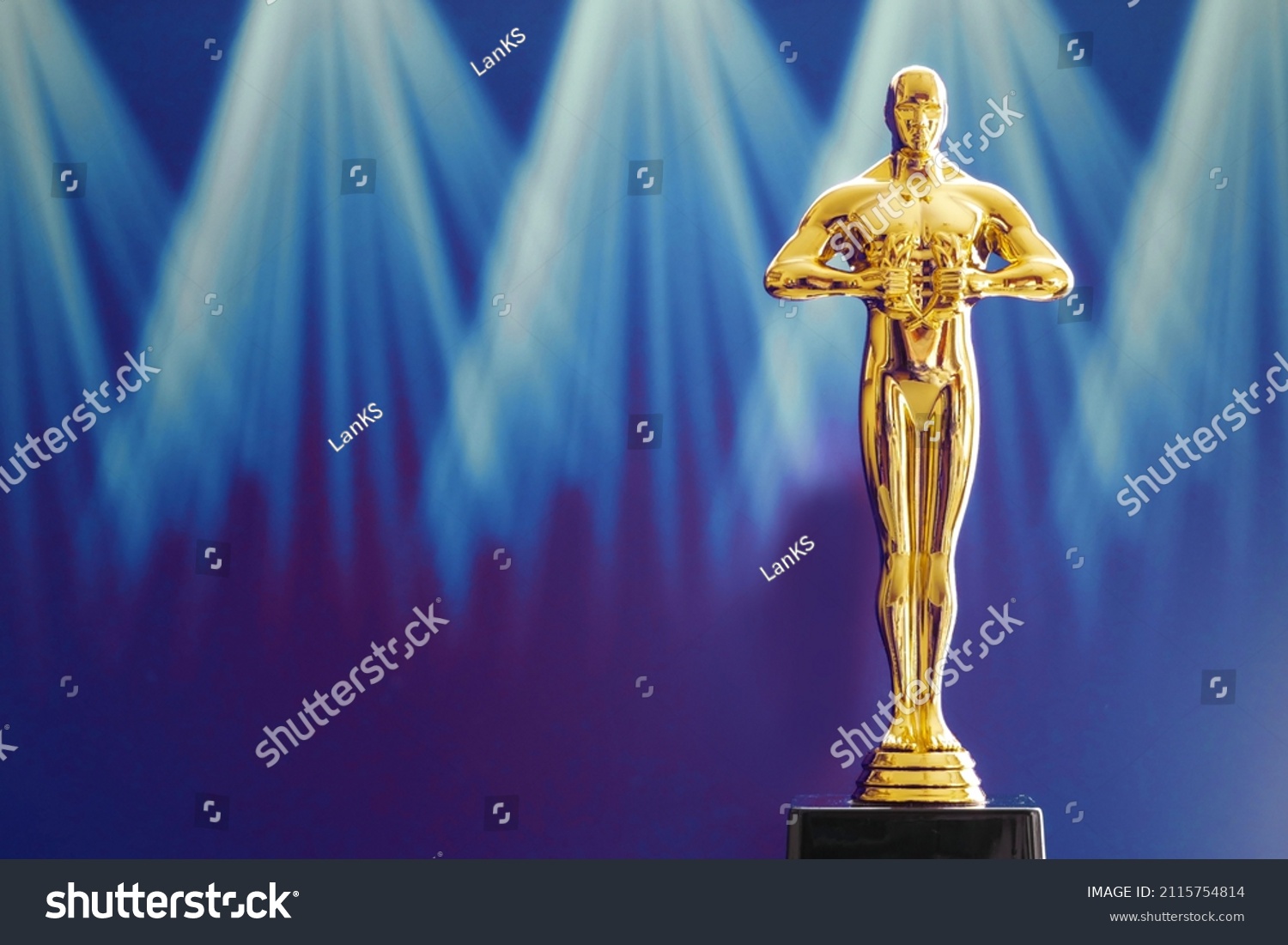 Hollywood Golden Oscar Academy award statue on light rays on black background with copy space. Success and victory concept. #2115754814