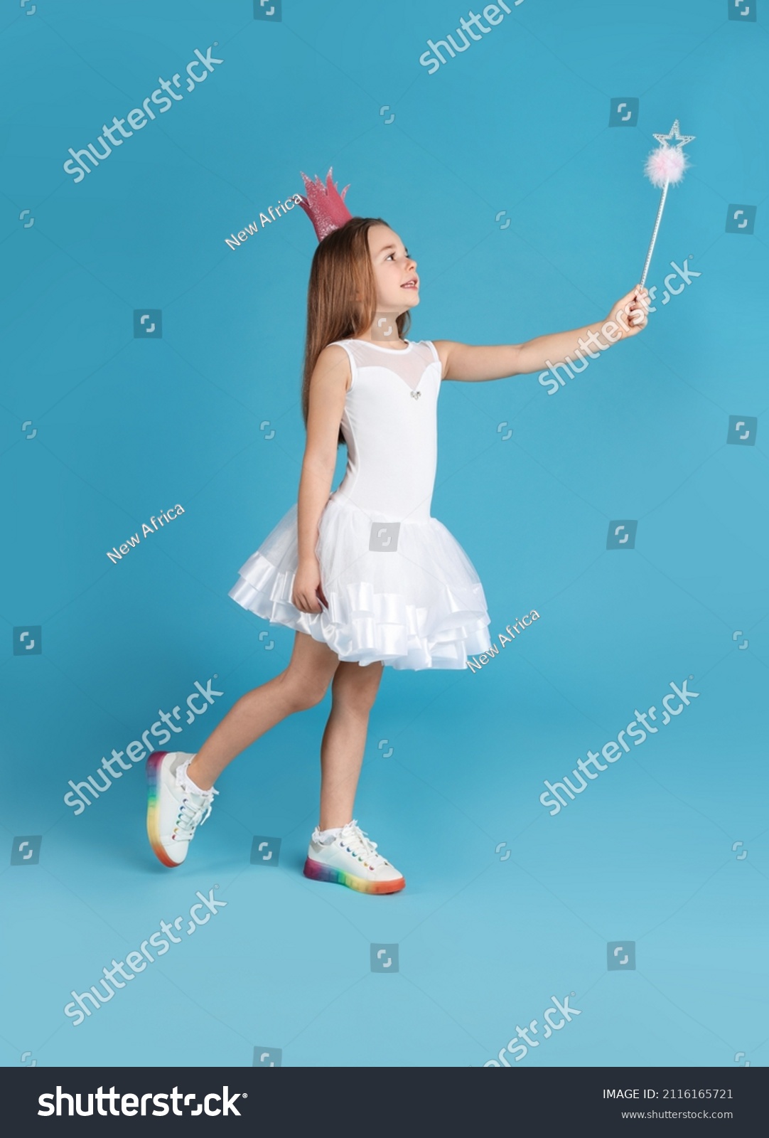 Cute girl in pink crown with magic wand on light blue background. Little princess #2116165721