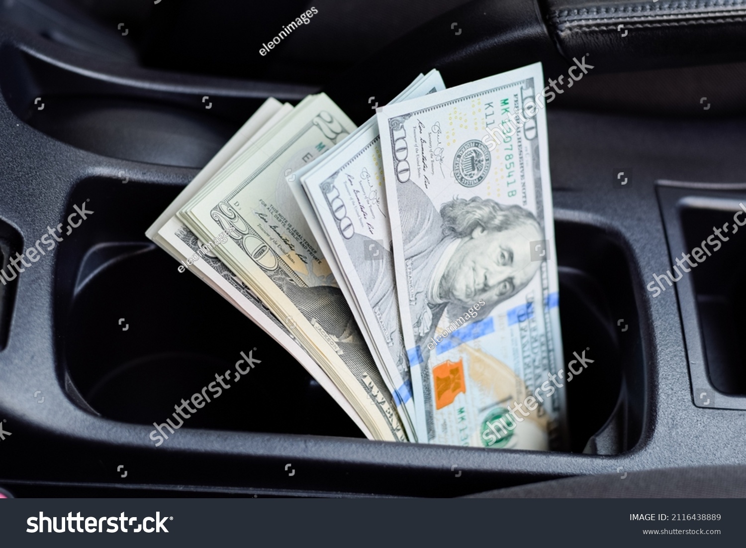 A wad of dollars inside the car. A wad of dollars inside the car. #2116438889