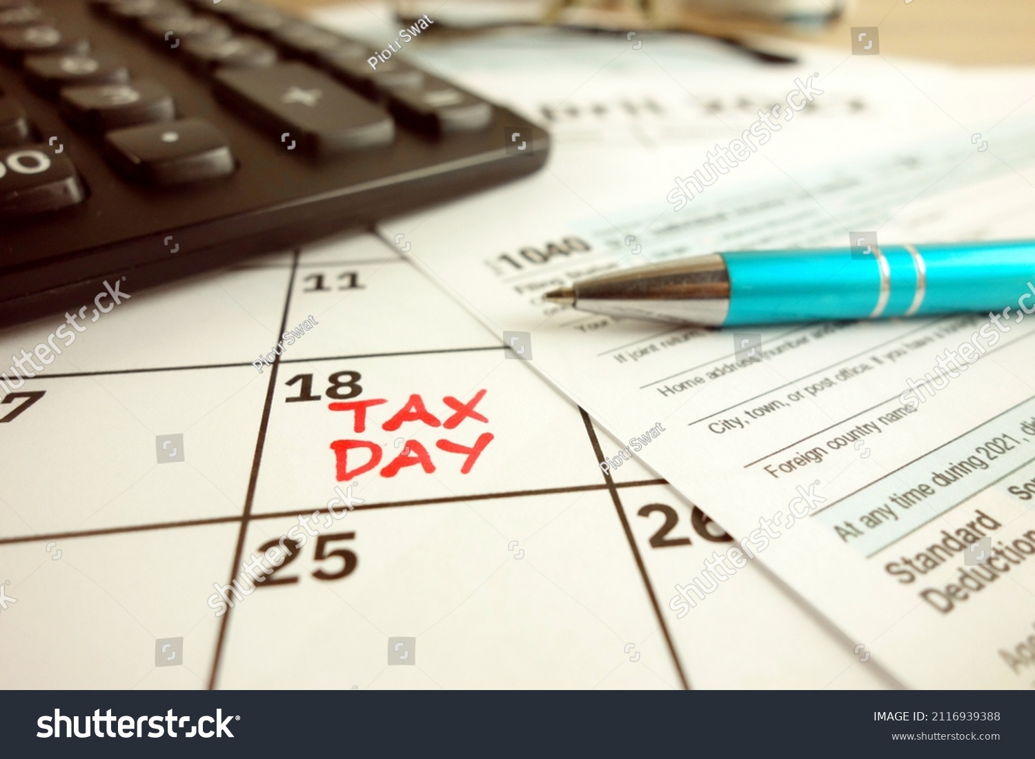Tax payment day marked on a calendar - April 18, 2022 with 1040 form, financial concept #2116939388