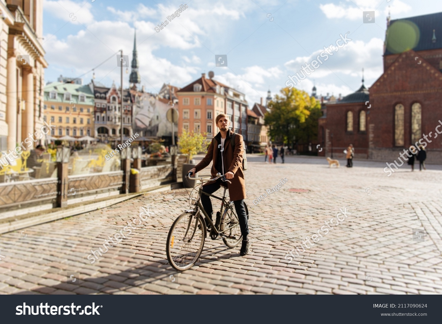 Young man riding a bike. Sustainable mobility transport New way of inclusive cities mobility. Green transportation. Sustainable climate neutral city goals. Green mobility and transportation #2117090624