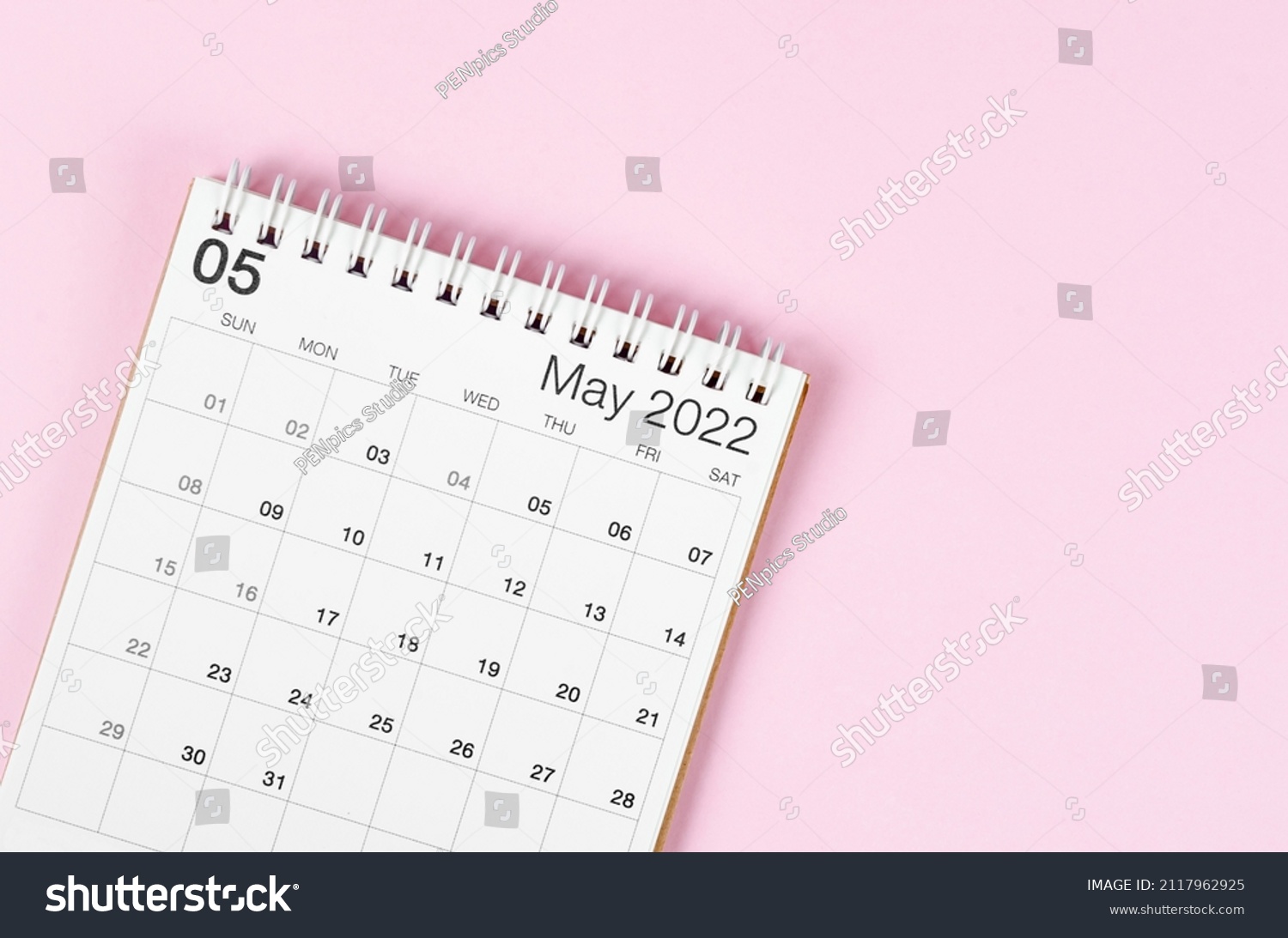 May 2022 desk calendar on pink background with empty space. #2117962925
