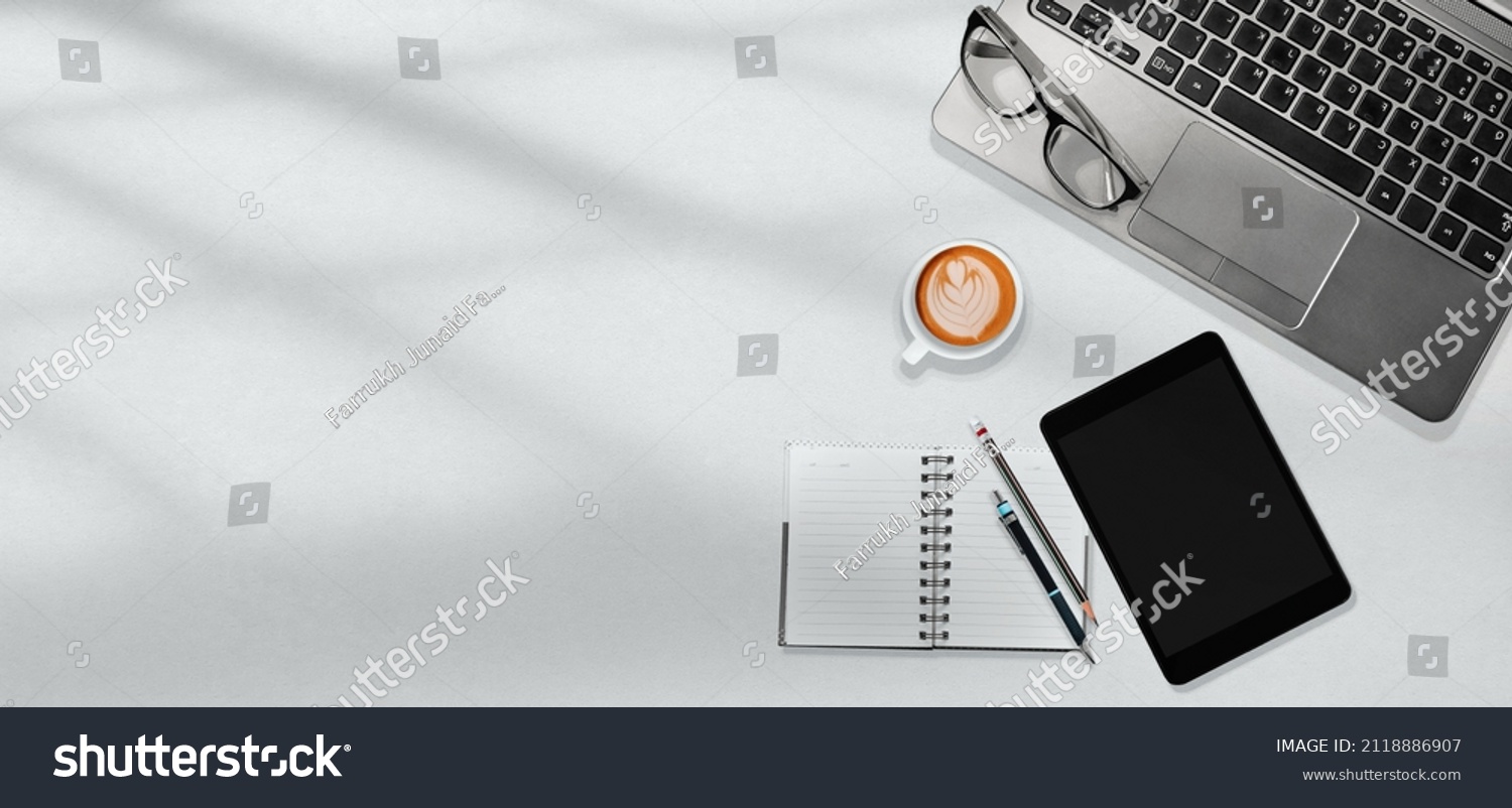White office table workplace with laptop, tablet, notebook, a cup of coffee art with copy space design for web banner, brochure, background. Flatlay, Top view. #2118886907