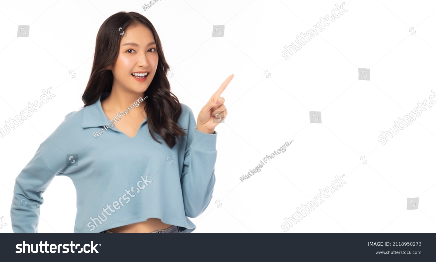 Beautiful young Asian woman pointing up to copy space and looking at camera with smile face and happiness Pretty girl act like a satisfied product, use for advertising with white background copy space #2118950273
