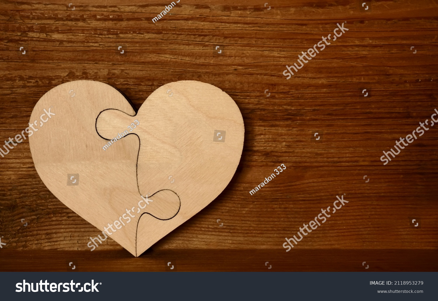 complete wooden heart shape jigsaw puzzle on wood board  background . 2 two pieces. two person in relationship.  #2118953279