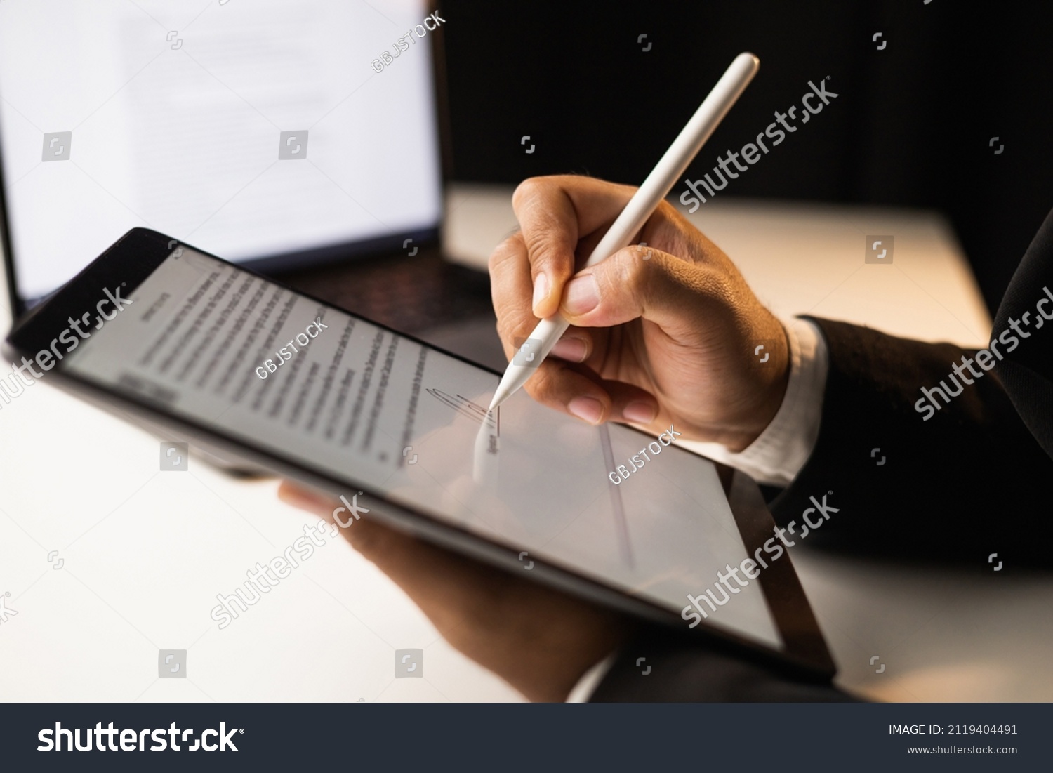 Close up businessman hand electronic Signature on Tablet by Stylus. Write business agreement of contract. Man signing contract on tablet. Business and technology concept. #2119404491