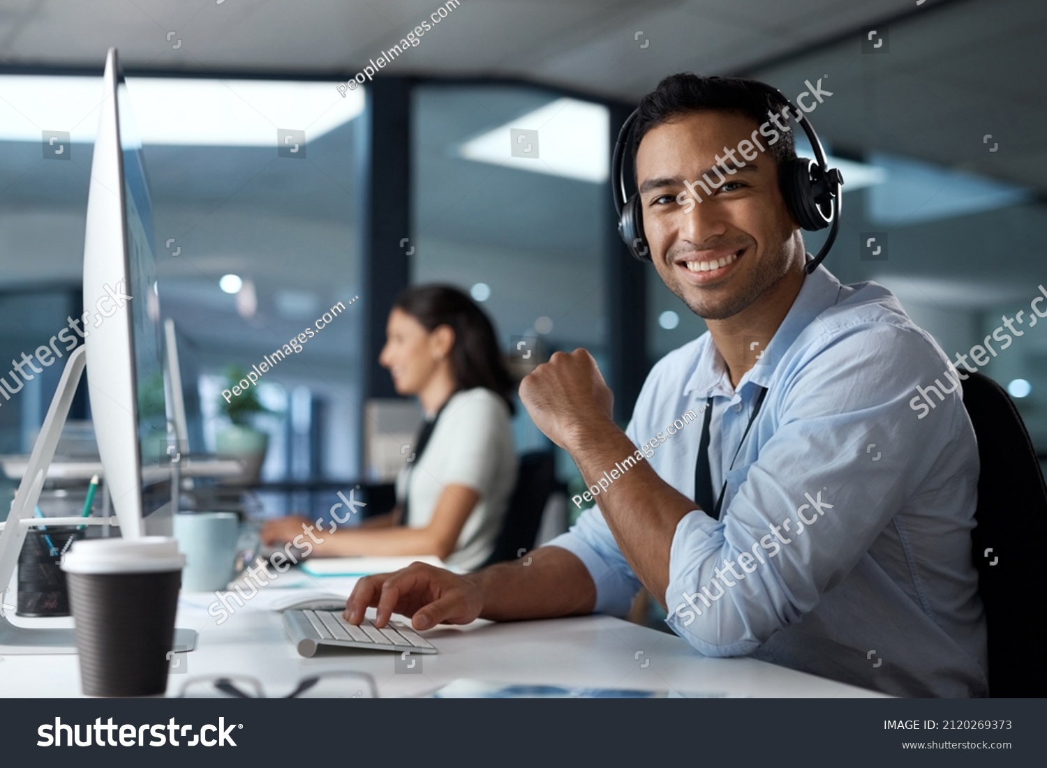 The customer is the real hero of this story. Portrait of a young man using a headset and computer in a modern office. #2120269373