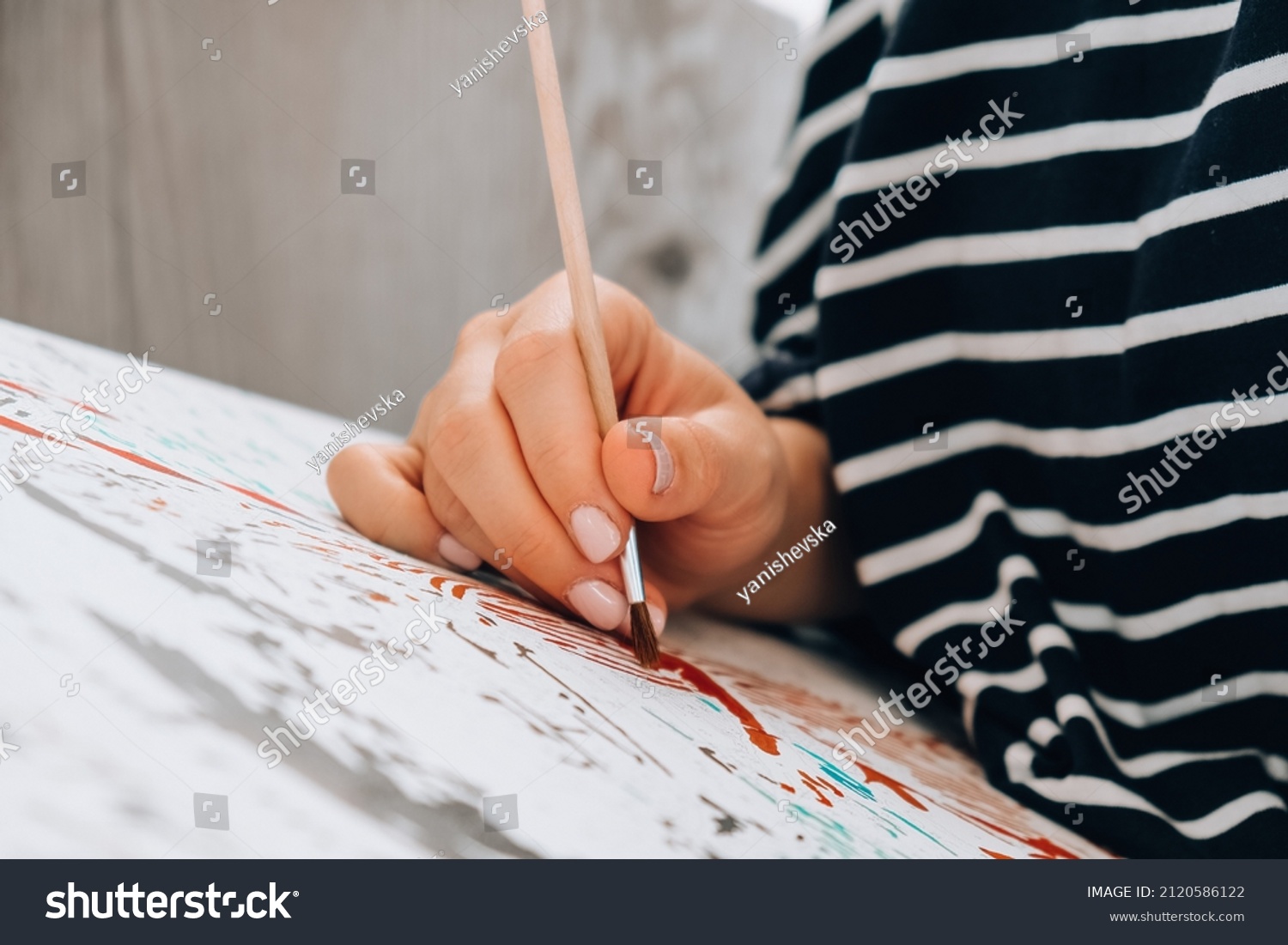 Painting on canvas by numbers and numbered jars of paint. Woman draws with a brush painting by numbers on canvas. Creative hobby. Painting for beginners. Leisure activity for stay home lockdown #2120586122
