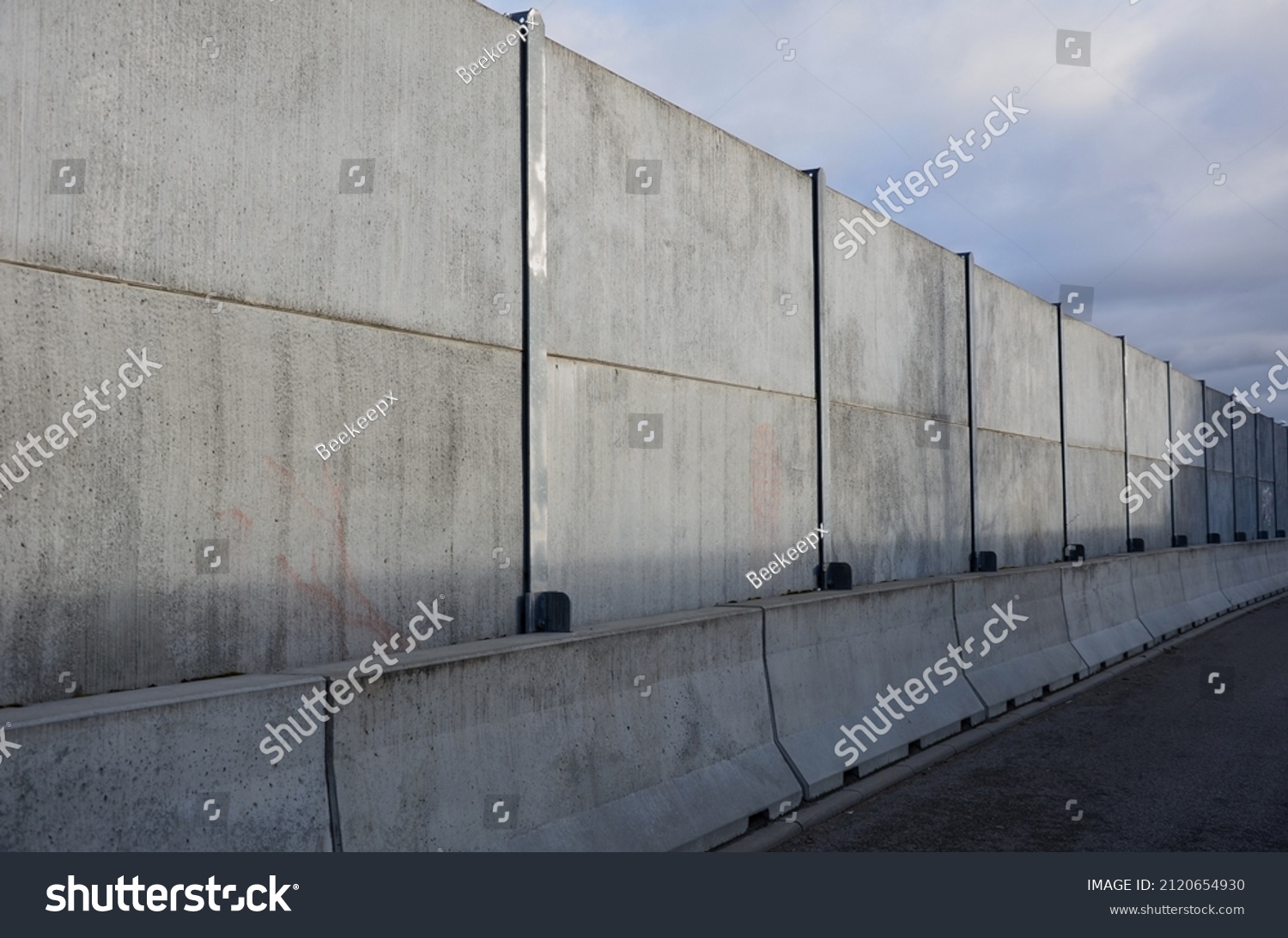 soundproof wall made of concrete porous ribbed material. fence of gray blocks embedded in metal beams, on street. road traffic noise  garden and residential area. protection of Jerusalem, rocket #2120654930