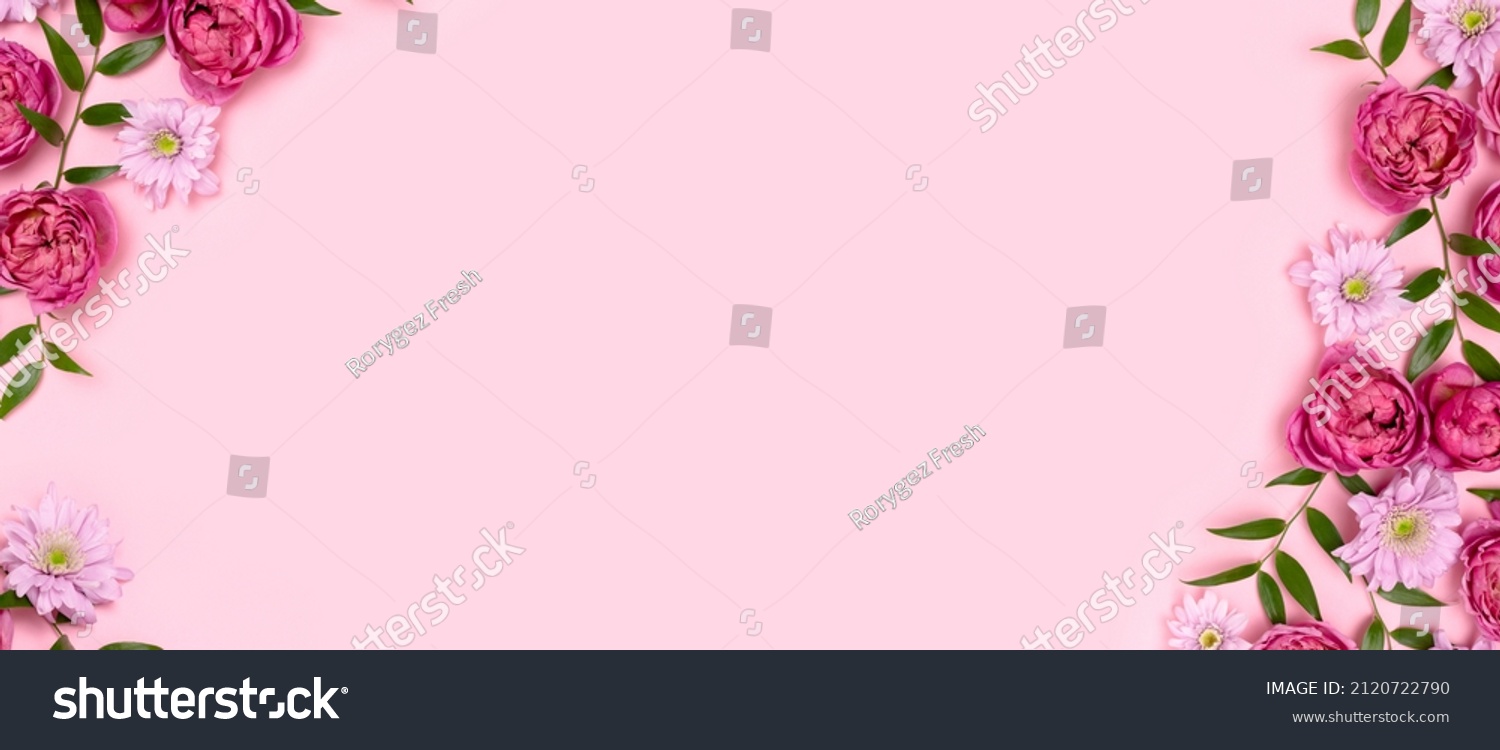 Banner with frame made of rose flowers and green leaves on a pink background. Springtime composition with copyspace. #2120722790
