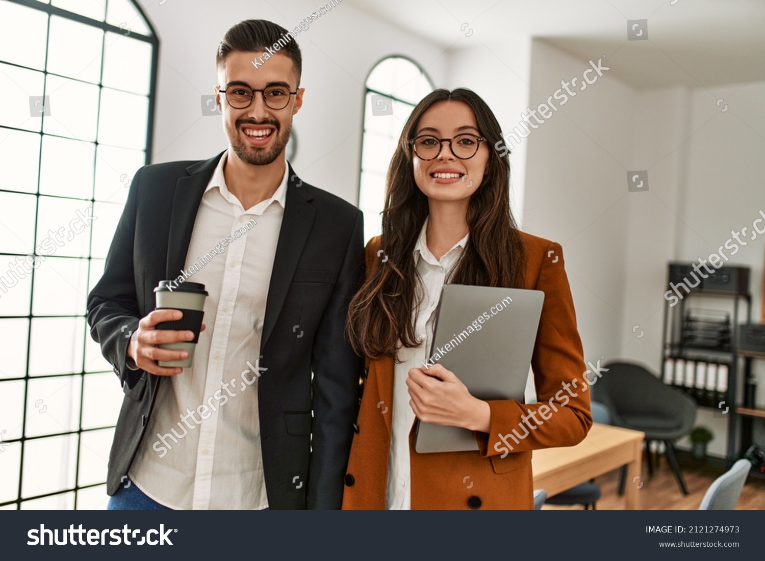Two hispanic business workers smiling happy drinking coffee at the office. #2121274973