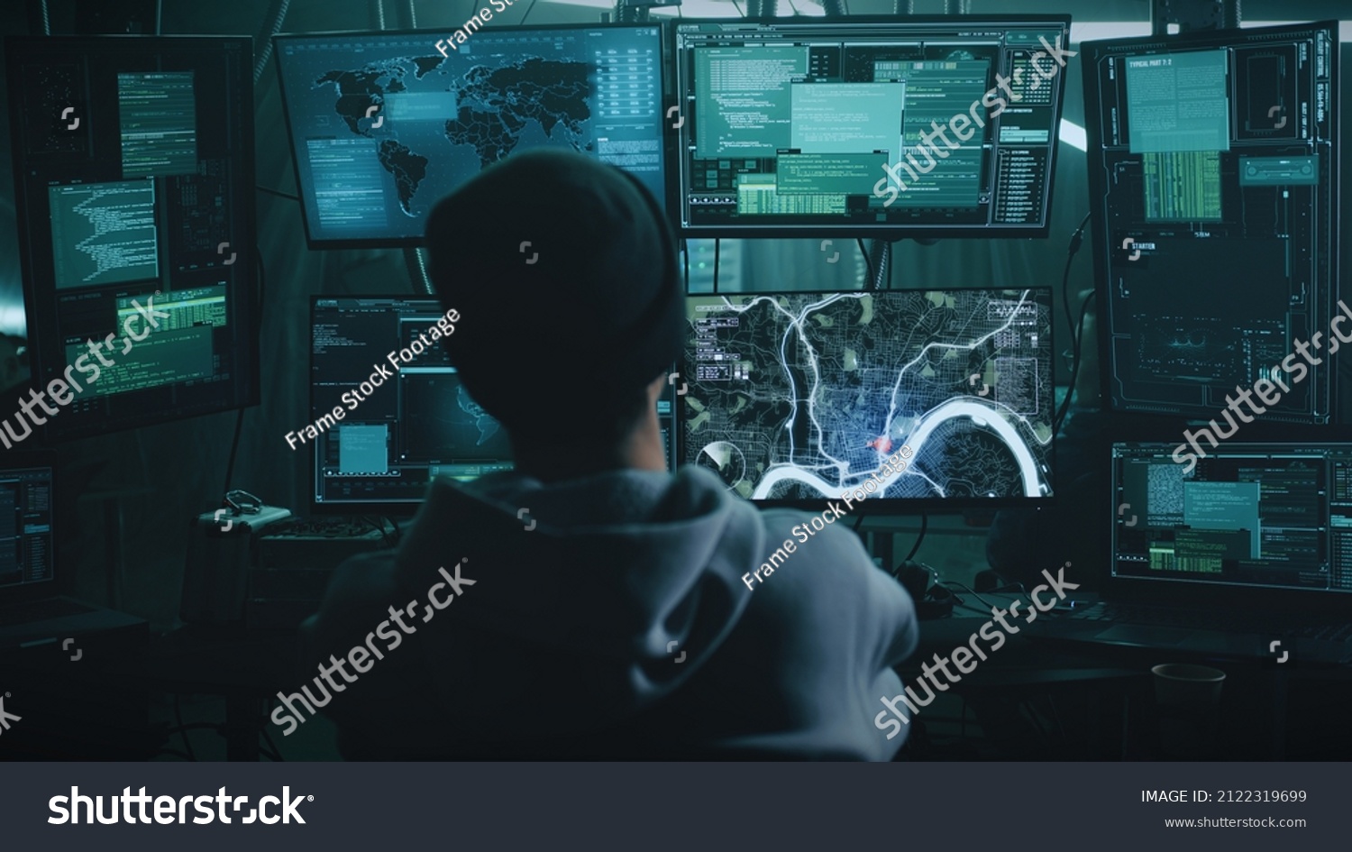 Teenage hacker with glasses watching a car on a monitor and pressing a keyboard in a dark cybercriminal hideout with lamps during a cyberattack #2122319699