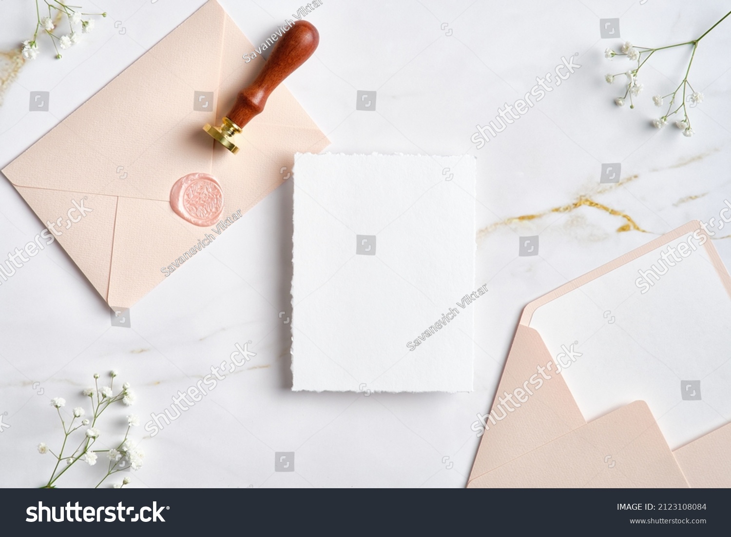 Wedding stationery set on marble desk top view. Blank paper card mockup, pastel pink envelopes with wax seal stamp, gypsophila flowers. #2123108084