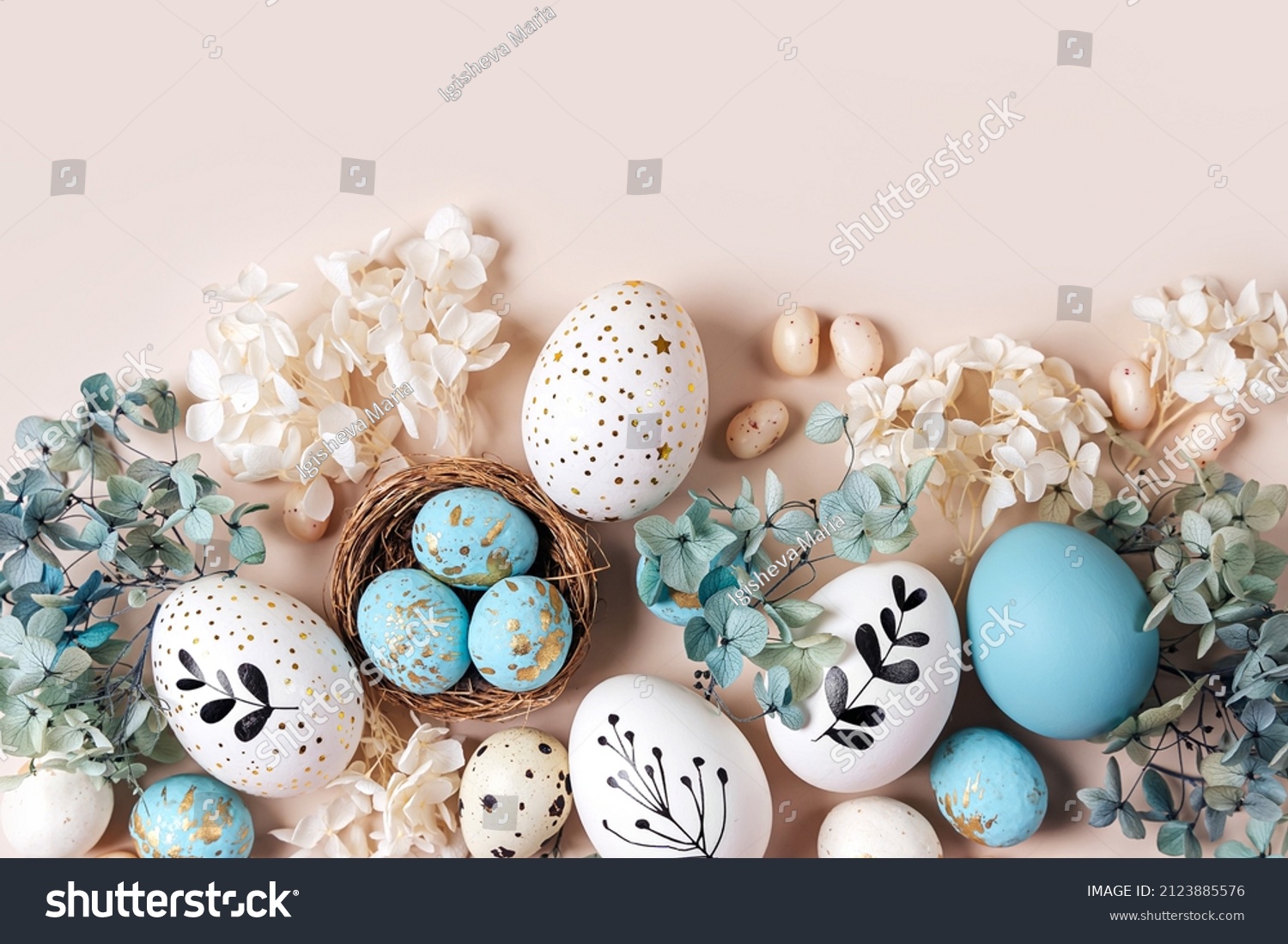 Easter eggs with sweets and flowers on beige. Happy Easter concept. White and blue eggs and cute nest with candy  #2123885576