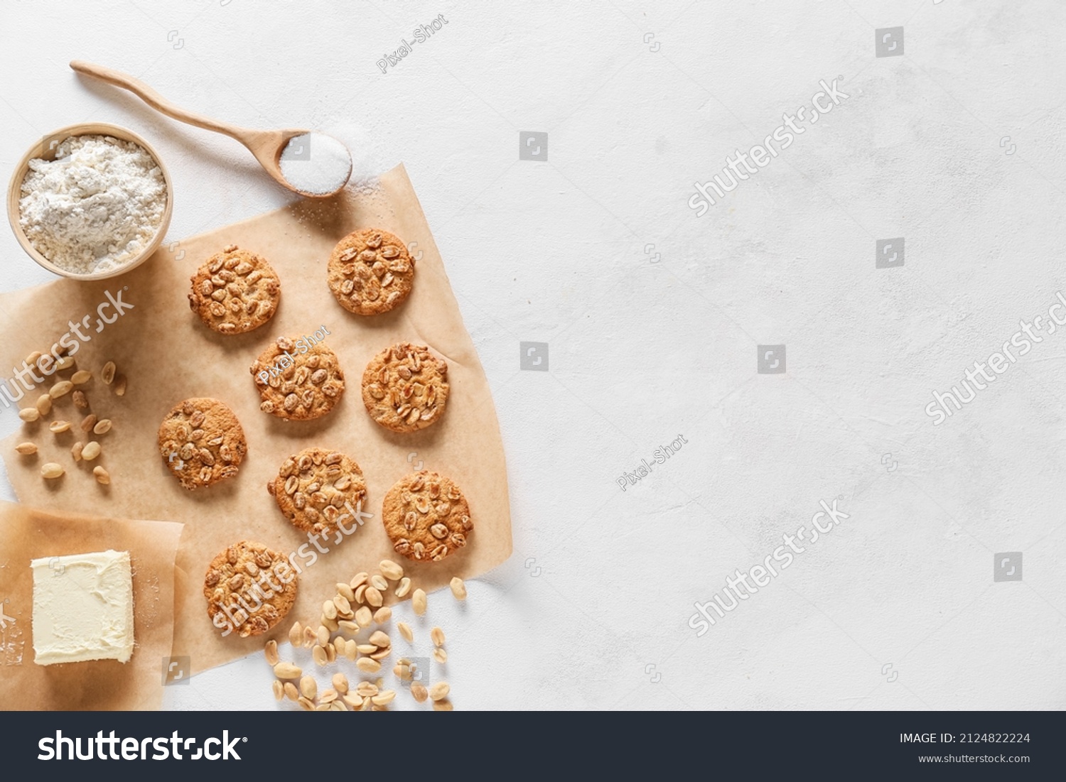 Parchment paper with tasty peanut cookies and ingredients on white background #2124822224