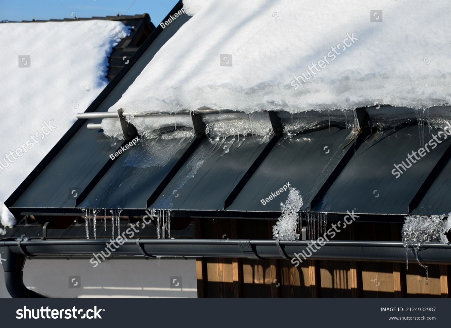 galvanized metal roof in the mountains with a bar against the rapid sliding of snow. If snow and ice quickly fall on people under the roof, they will be injured or dead. slows down the avalanche #2124932987