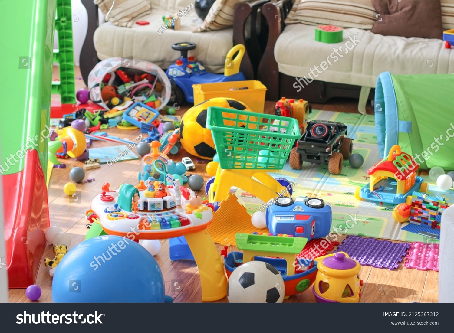 Adorable toddlers playing among the many toys at home. A mess in the children's room, a lot of toys in the children's room. Dirty house. Children's room. Selective focus  #2125397312