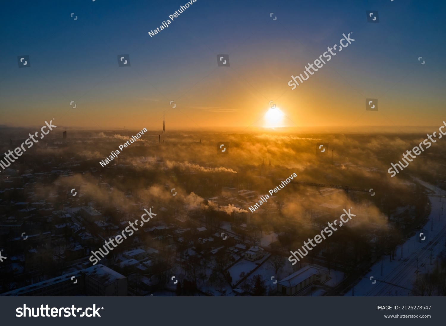 Aerial view of bright yellow sunset over white dense clouds with blue sky overhead. #2126278547