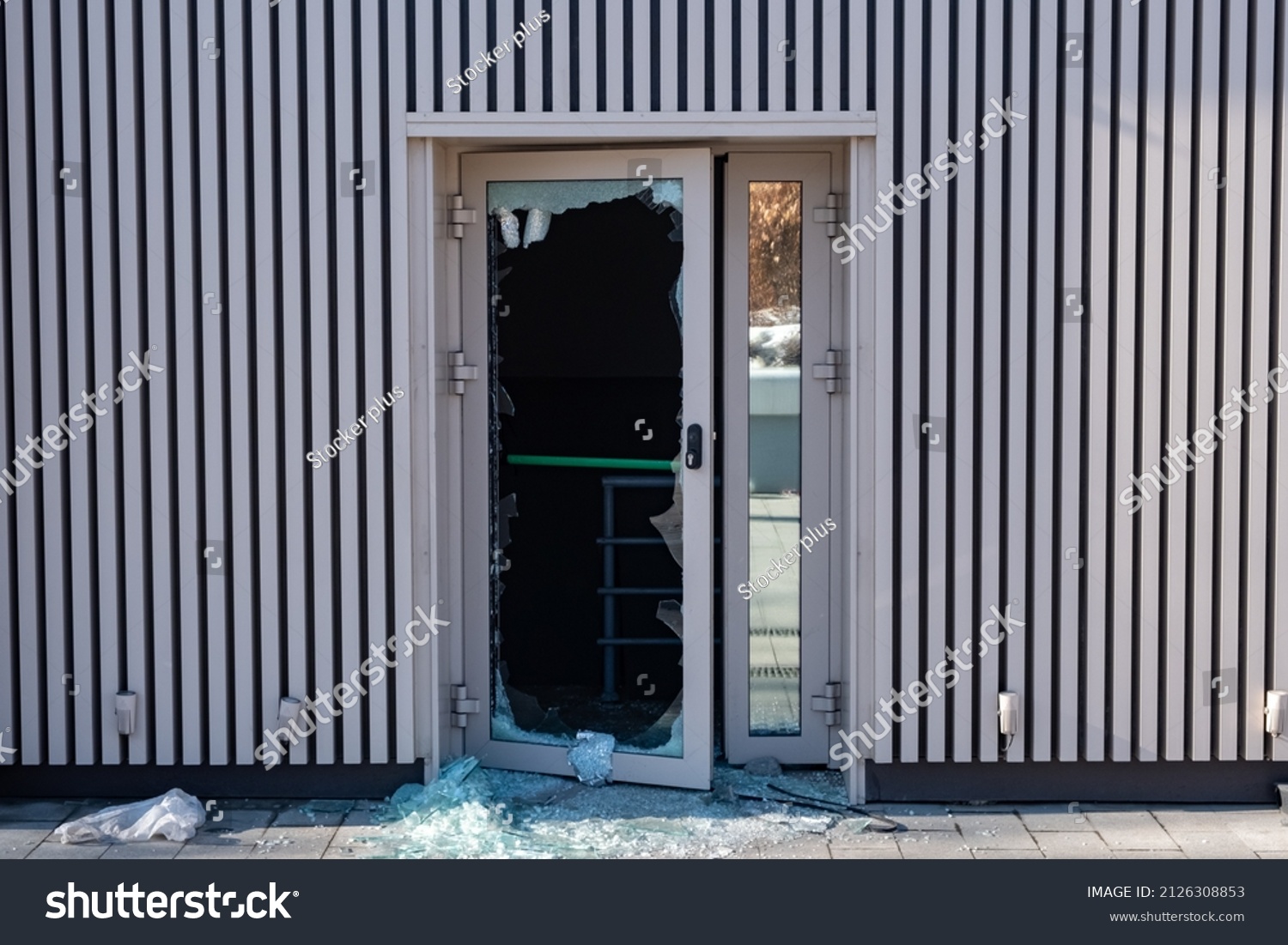 Broken glass door in shopping mall. Vandalism, burglary concept. Insurance concept. Cracked glass due to crime, robbery of shop concept. #2126308853