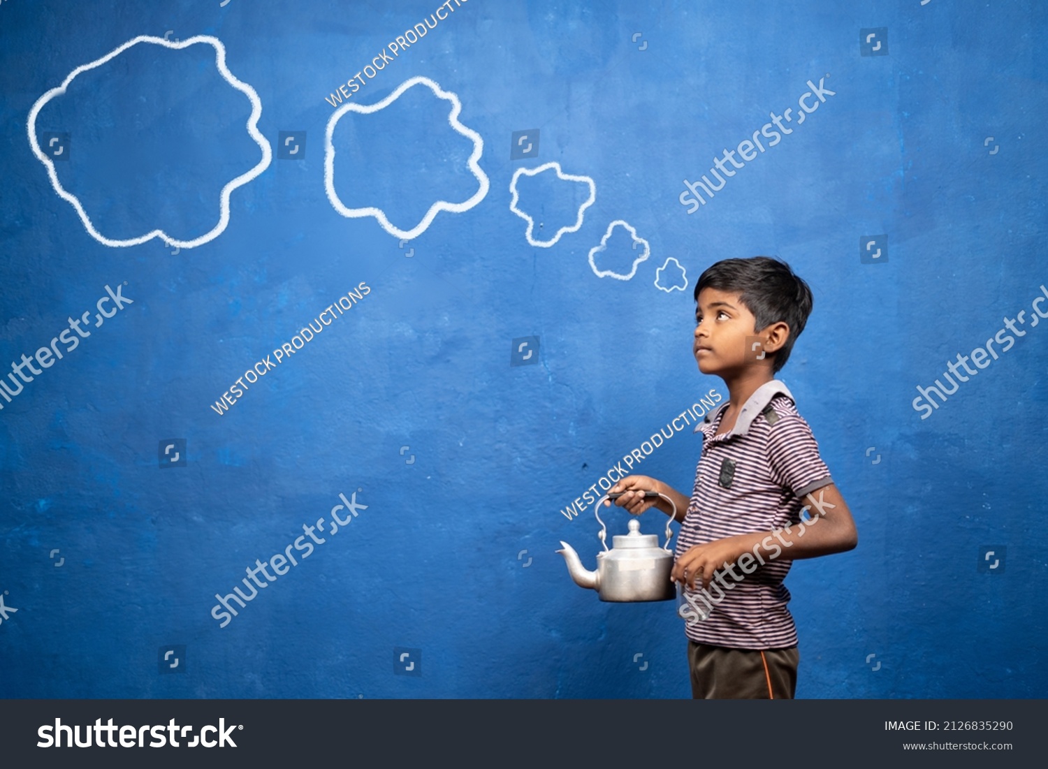 poor tea selling kid thinking by holding tea glass and container in hand with cloud doodle drawing on blue background - cocept of poverty, child labour and imagination #2126835290