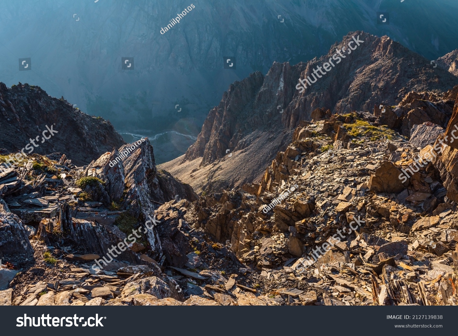 Awesome mountain view from cliff at very high altitude. Scenic landscape with beautiful sharp rocks near precipice and couloirs in sunlight. Beautiful mountain scenery on abyss edge with sharp stones. #2127139838