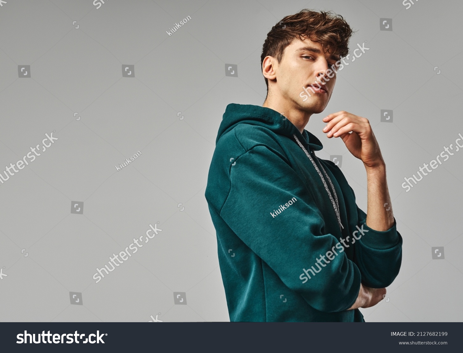 Handsome man in green hoodie isolated on gray background #2127682199