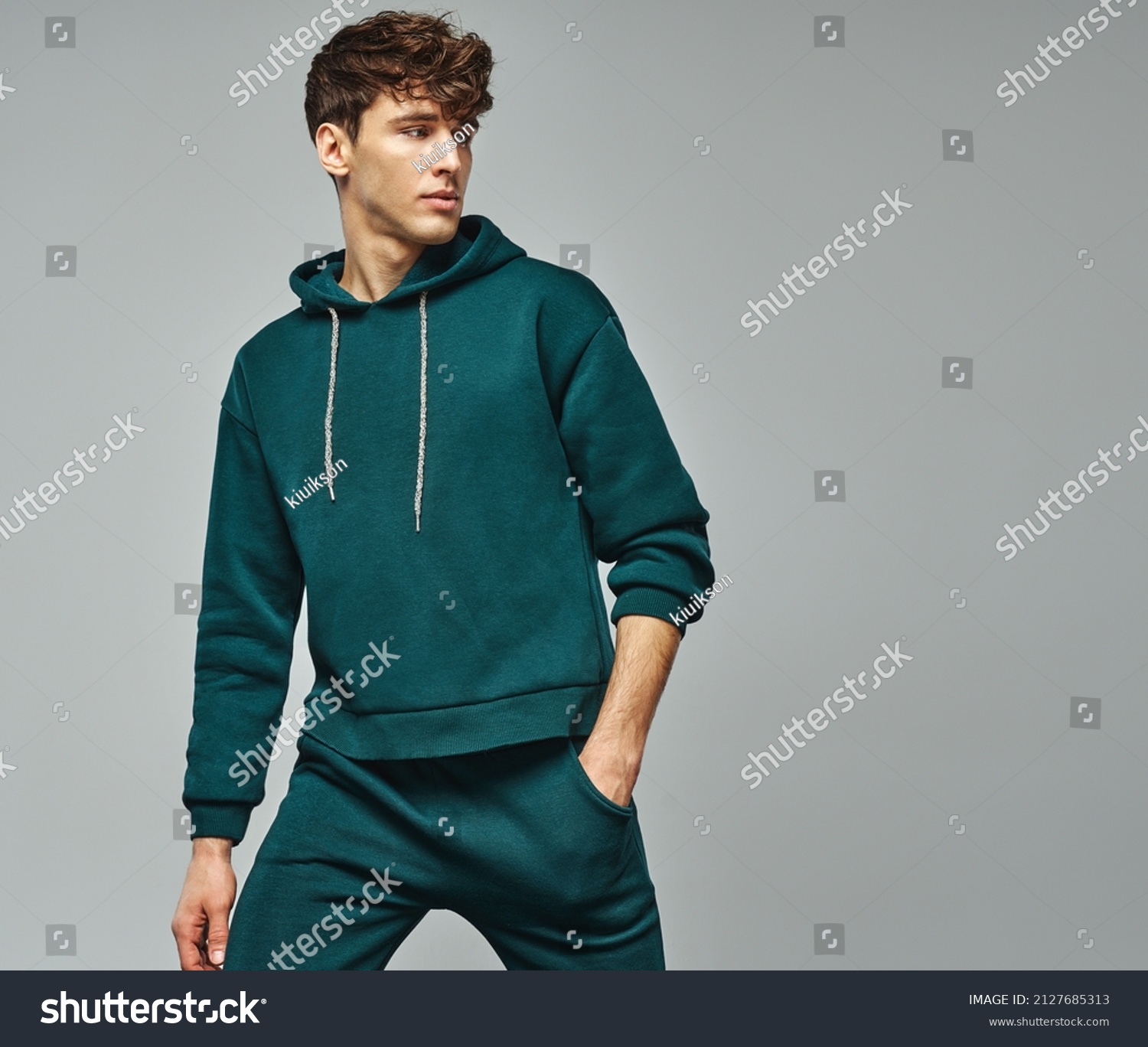 Handsome man wear of green set of track suit isolated on grayl background #2127685313