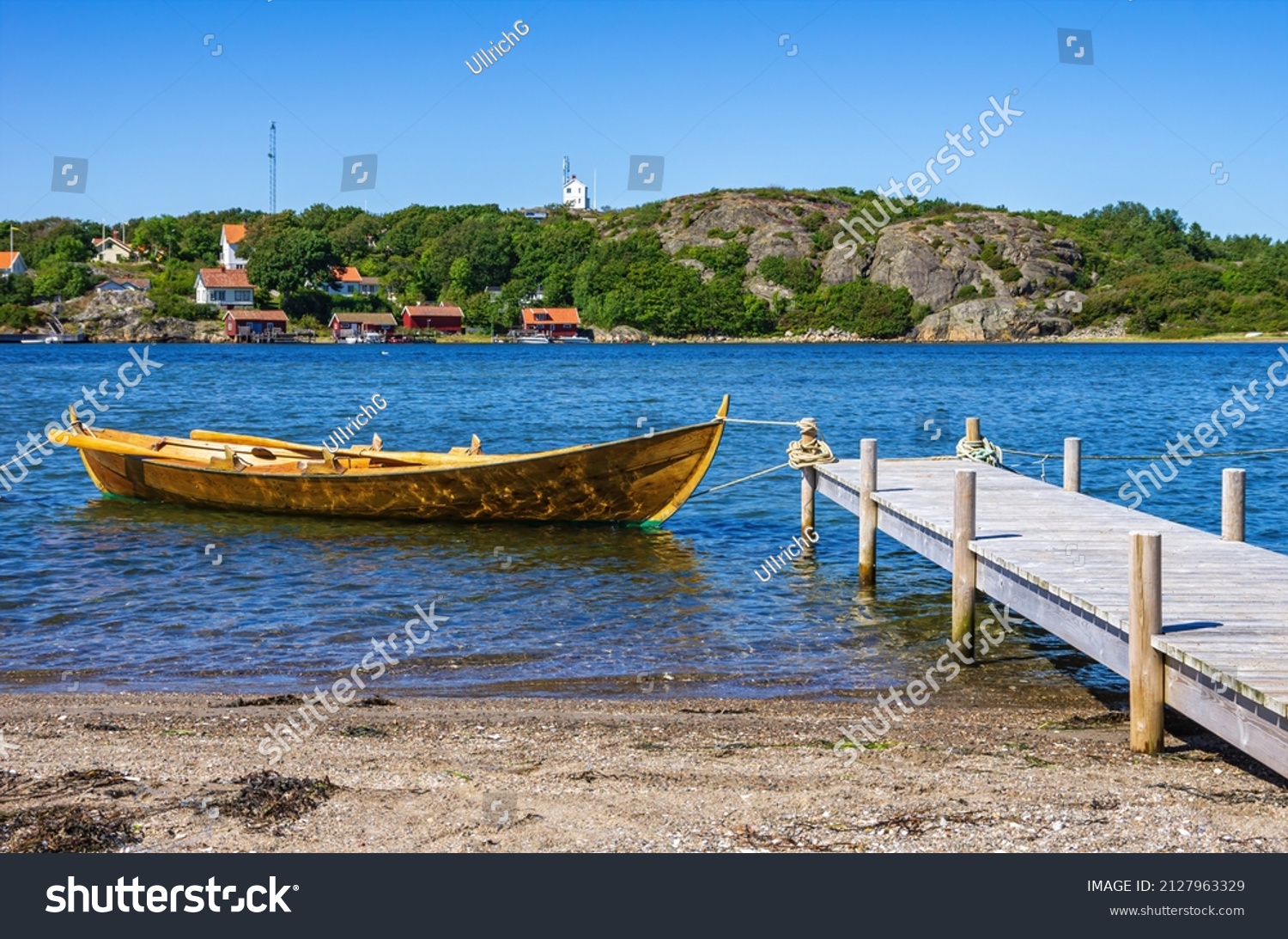 Single rowboat at a landing stage on the North shore of the South Koster Island (Sydkoster) with a beautiful view of the North Koster Island (Nordkoster), Bohuslän, Västra Götalands län, Sweden. #2127963329