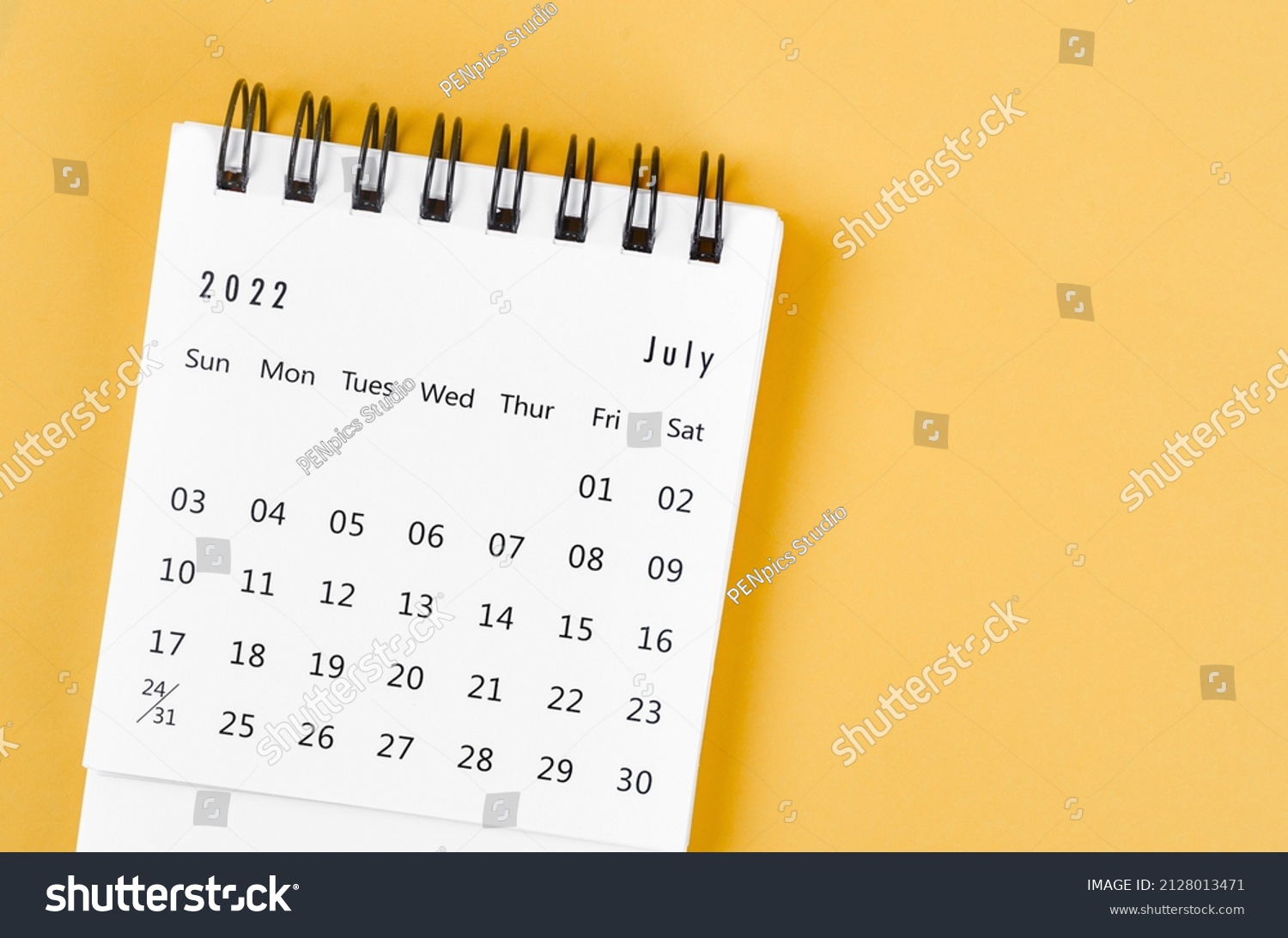 The July 2022 desk calendar on light yellow background. #2128013471