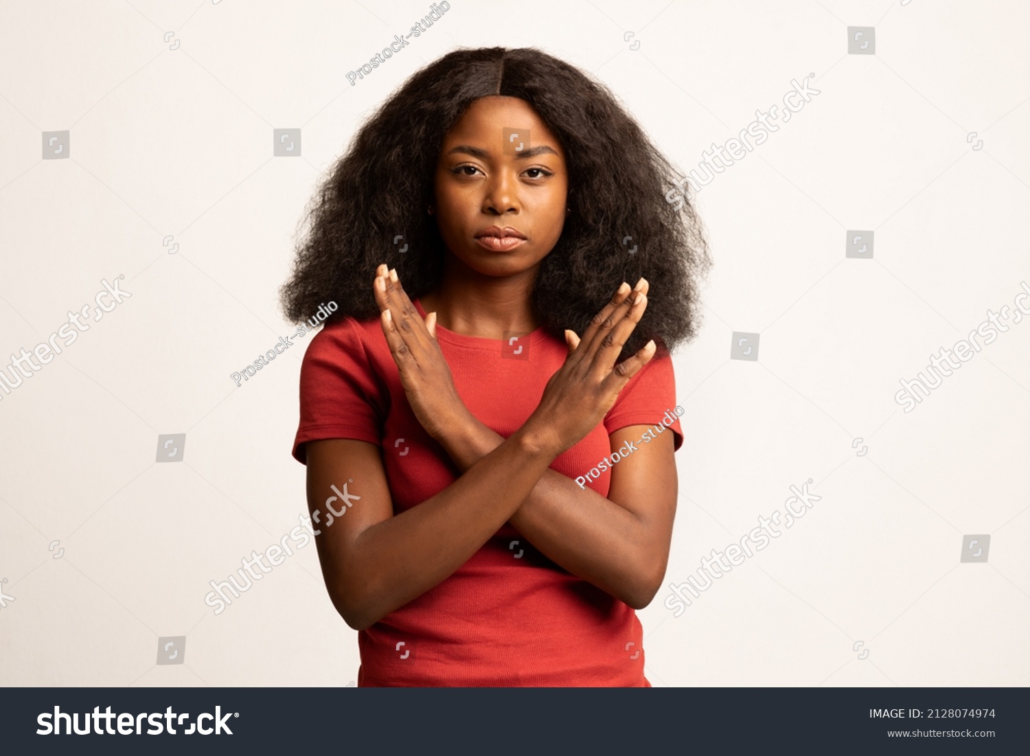Portrait Of Young Black Female Showing Stop Gesture With Crossed Hands, Serious Millennial African American Woman Refusing Something While Posing Over White Studio Background, Copy Space #2128074974