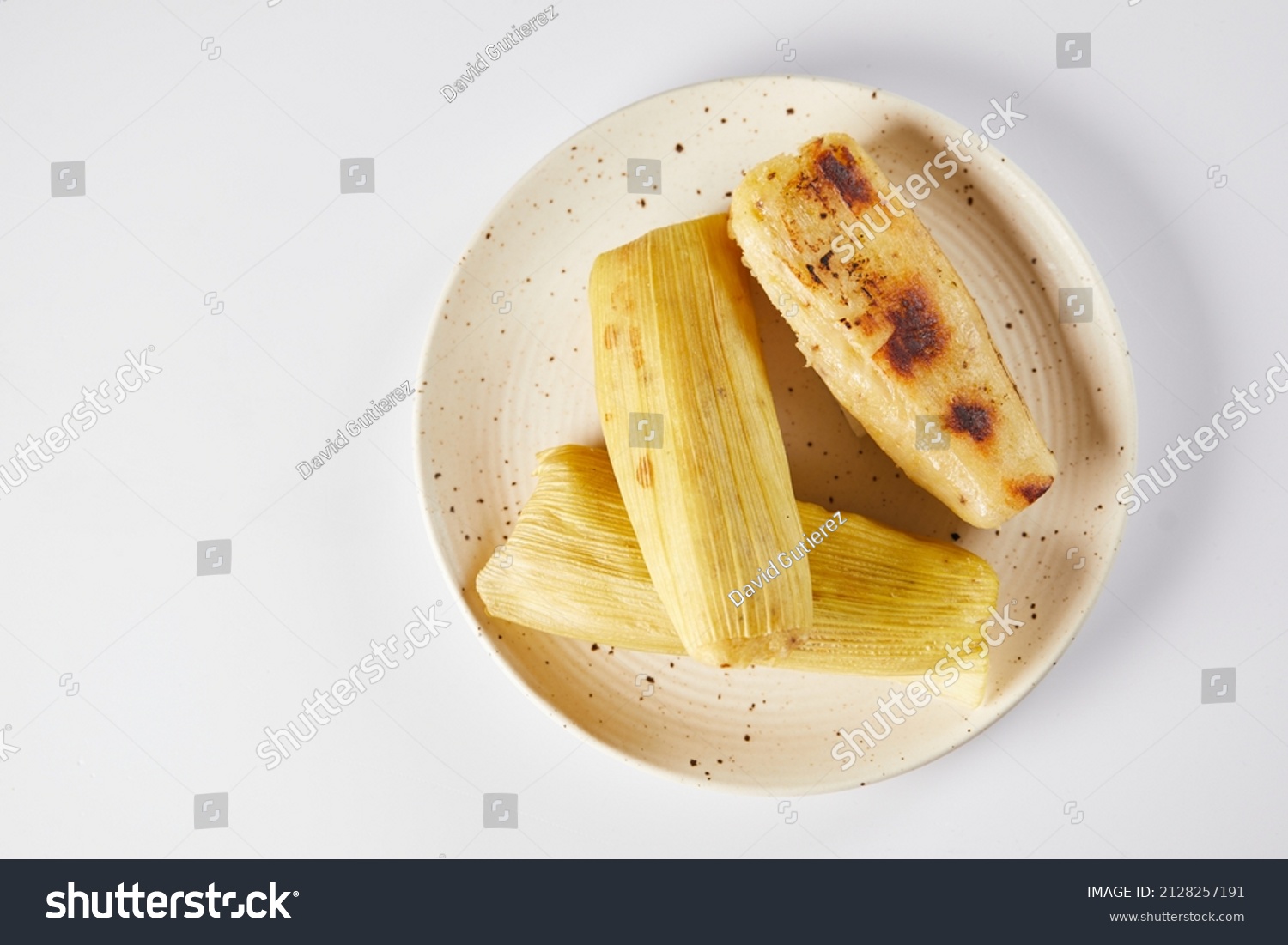 Humitas are savory steamed fresh corn cakes, a traditional Ecuadorian appetizer. On a white background.  #2128257191