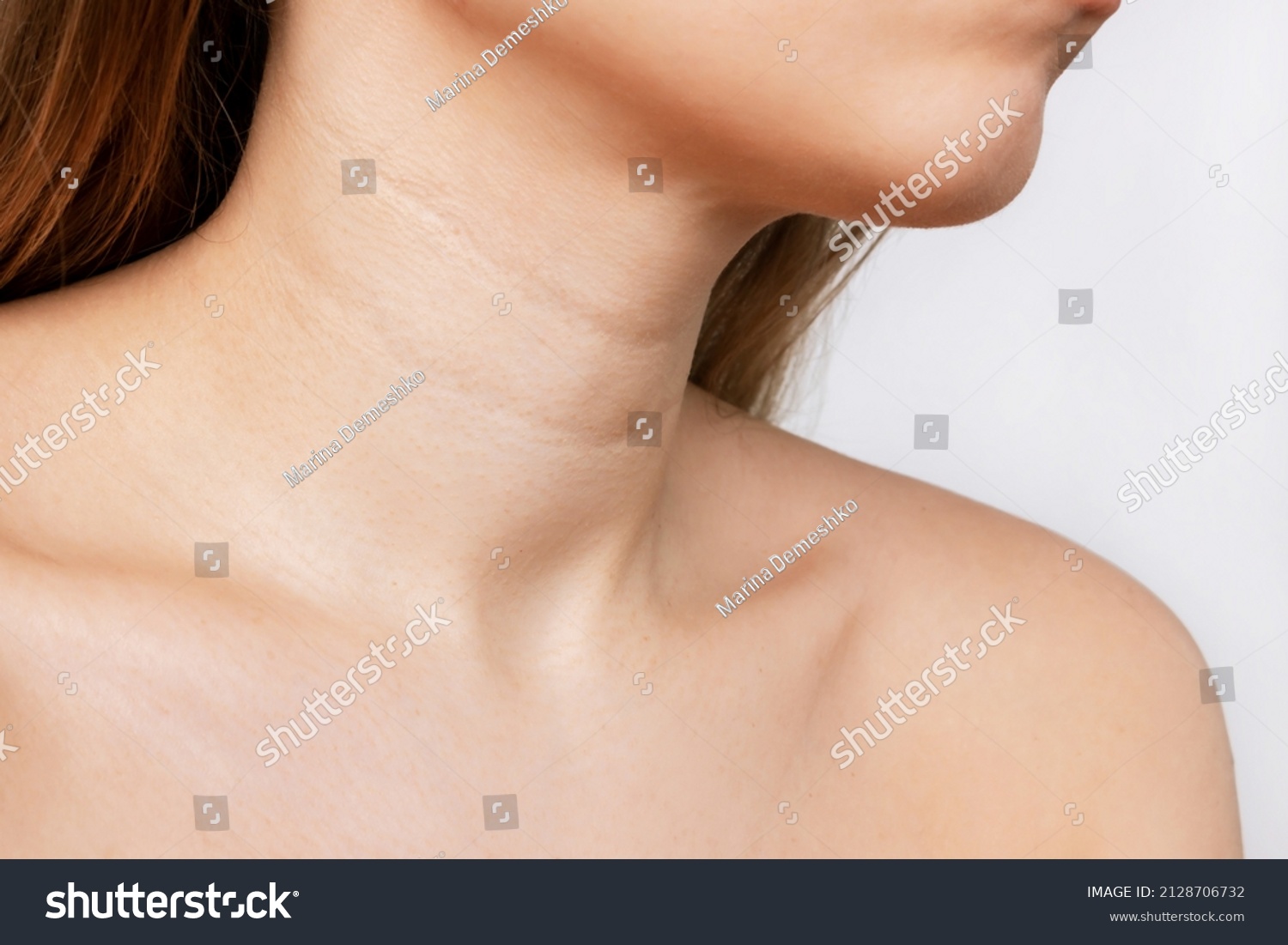 Сropped shot of a young woman with lines on the neck isolated on a white background. Wrinkles, creases, age-related changes, rings of Venus. Skin care #2128706732