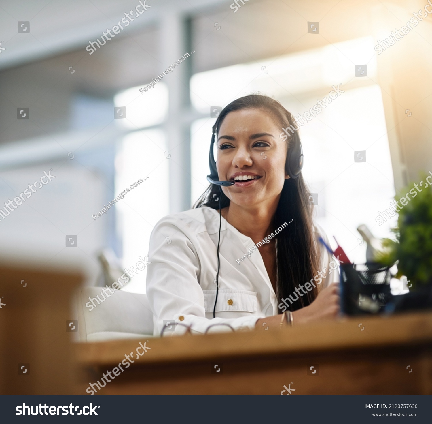 Be productive in helping customers. Shot of a female agent working in a call centre. #2128757630