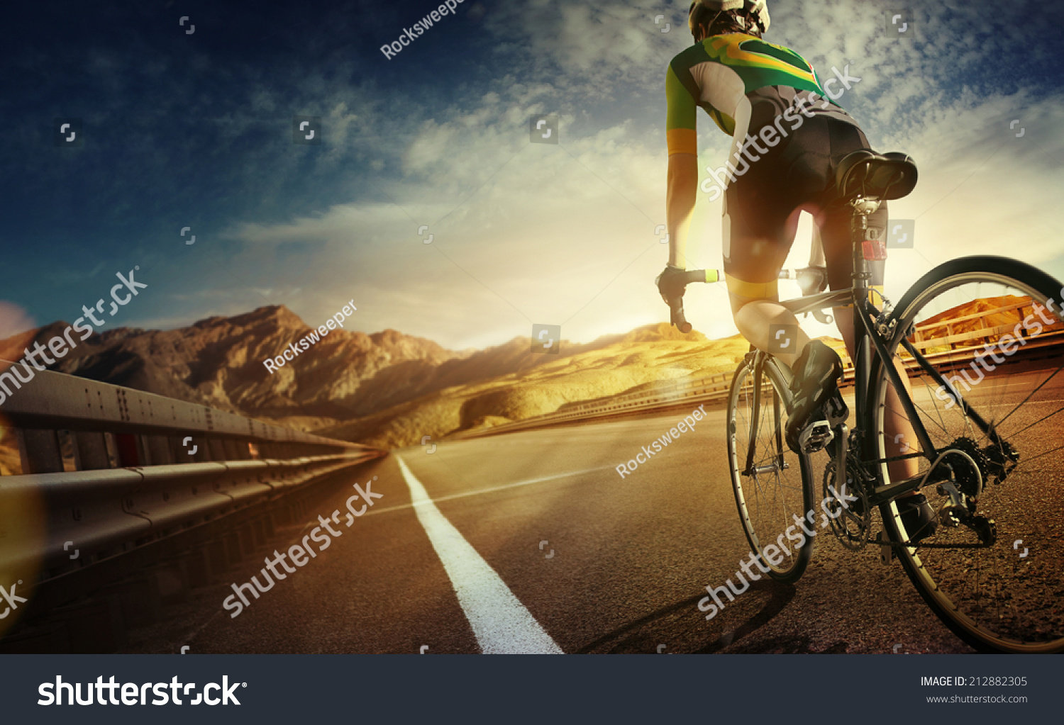 Cyclist riding a bike on an open road to the sunset  #212882305
