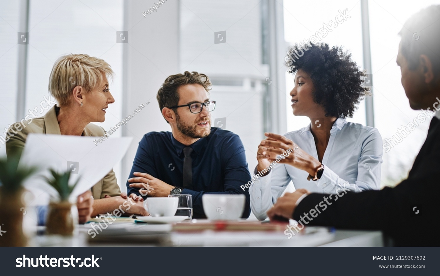 Give us difficult and well show you easy. Shot of a group of businesspeople sitting together in a meeting. #2129307692