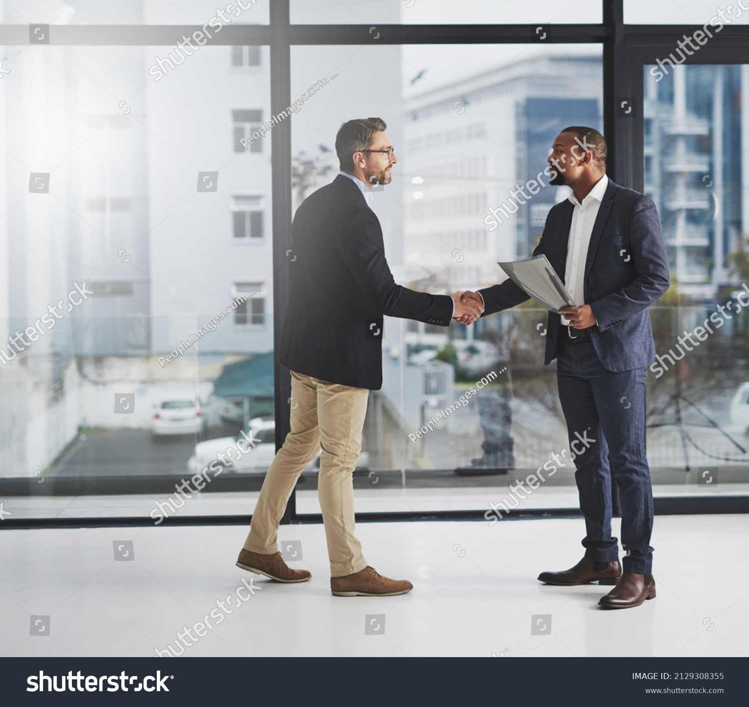 Combining corporate talent. Shot of two businessmen shaking hands at work. #2129308355