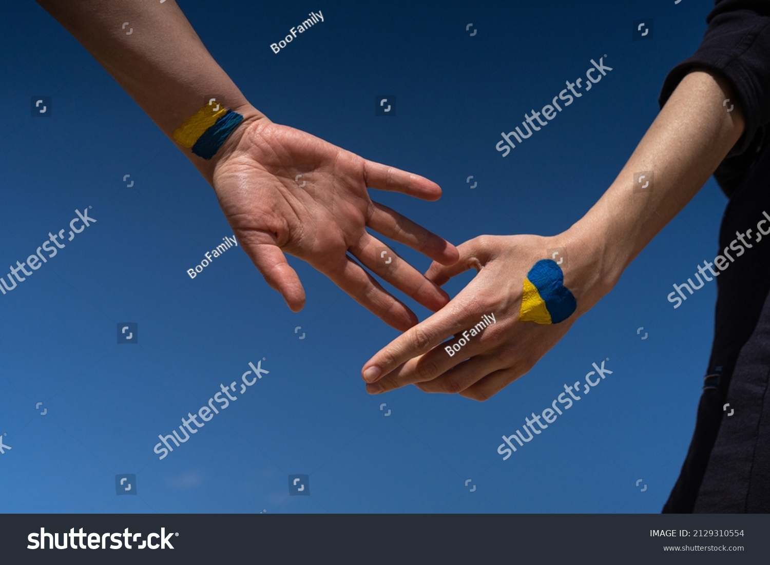 female hands painted in Ukraine flag colors yellow-blue. Stop the war and the power of Ukraine, patriotism and Kiev, strength and power #2129310554