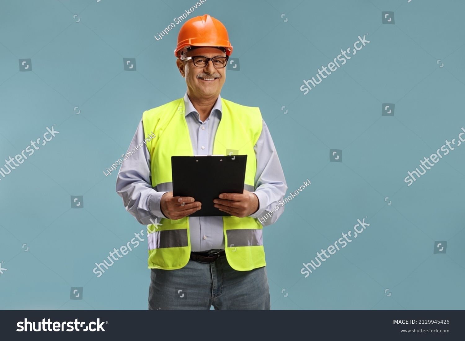 Construction site engineer with a reflective vest isolated over blue background #2129945426